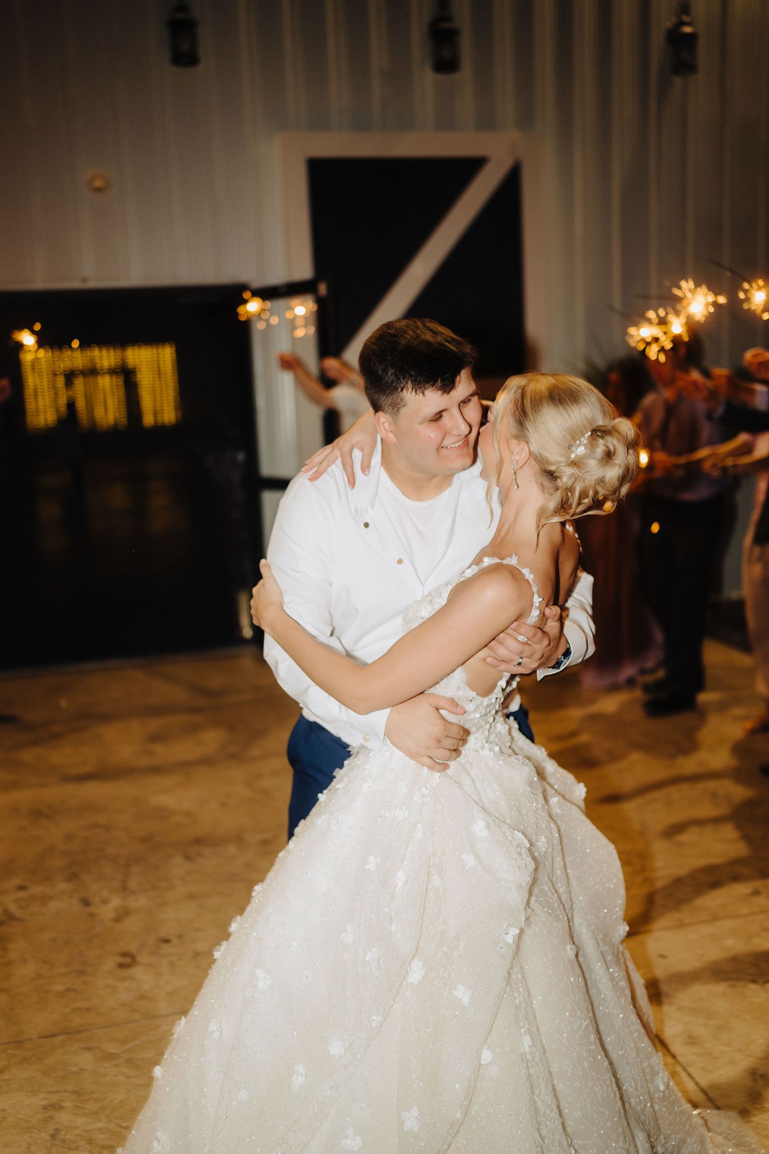 Couple sharing first dance in beautifully lit reception venue.