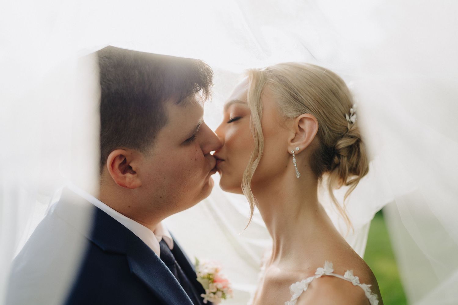 A romantic wedding moment captured against a light background.