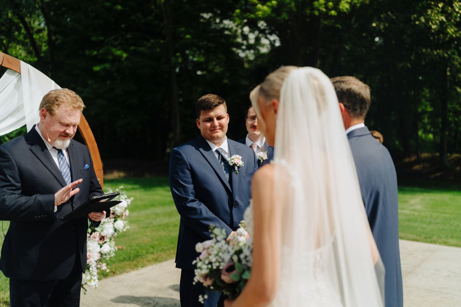 Outdoor wedding ceremony taking place in a lush garden setting.