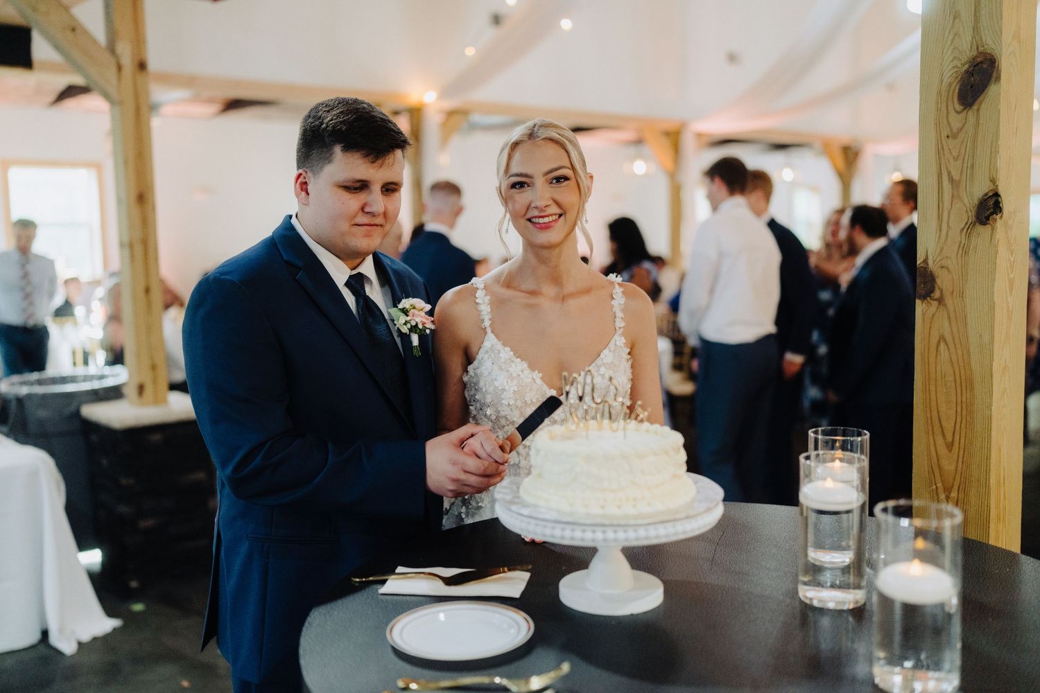 Wedding celebration inside a rustic venue with wooden beams and bright natural lighting.