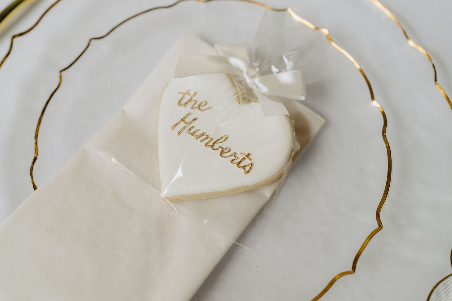 Elegant white wedding favors with gold foil details arranged on display.