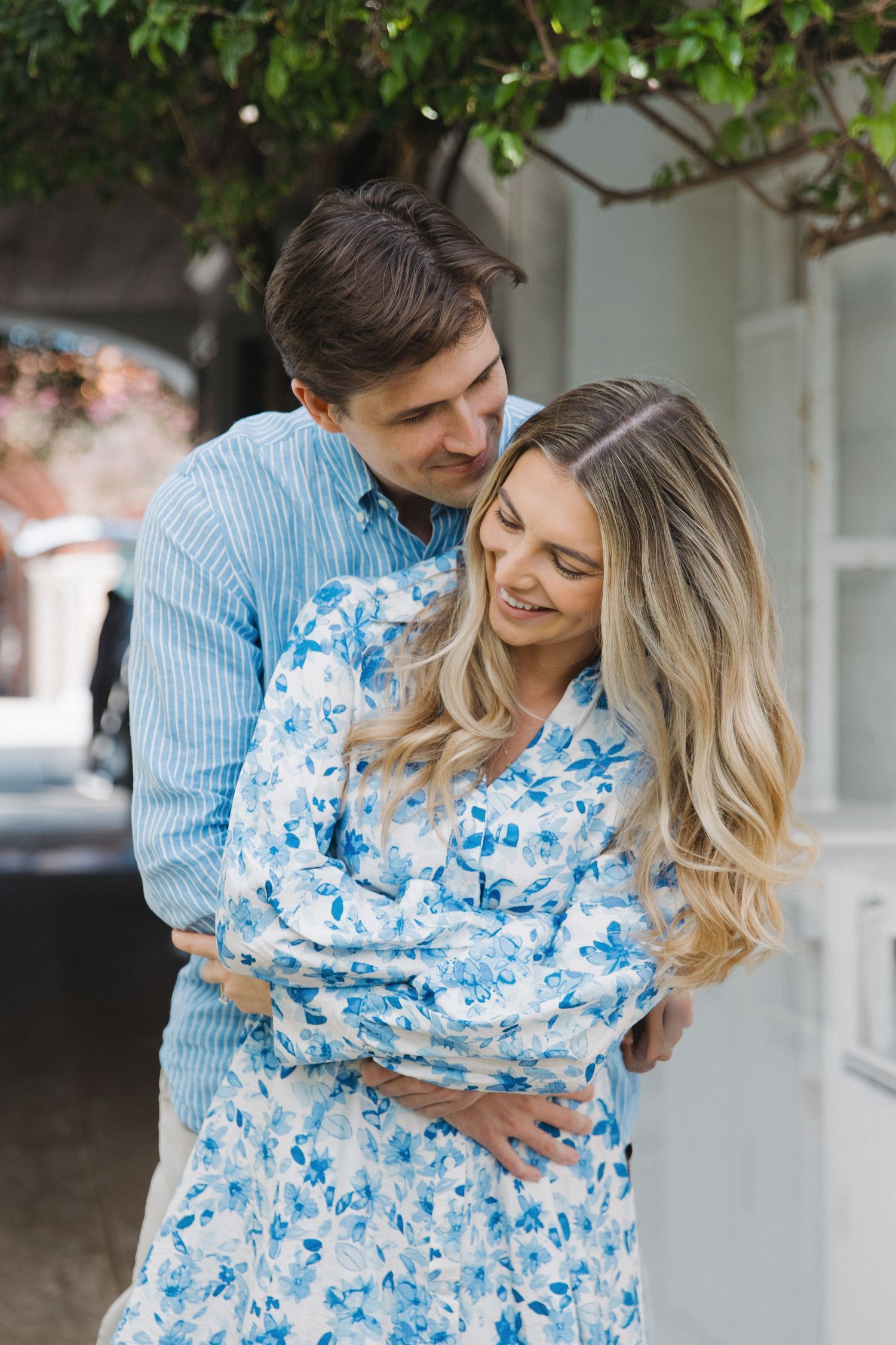 Couple embracing in a romantic sequence wearing blue and white floral dress.