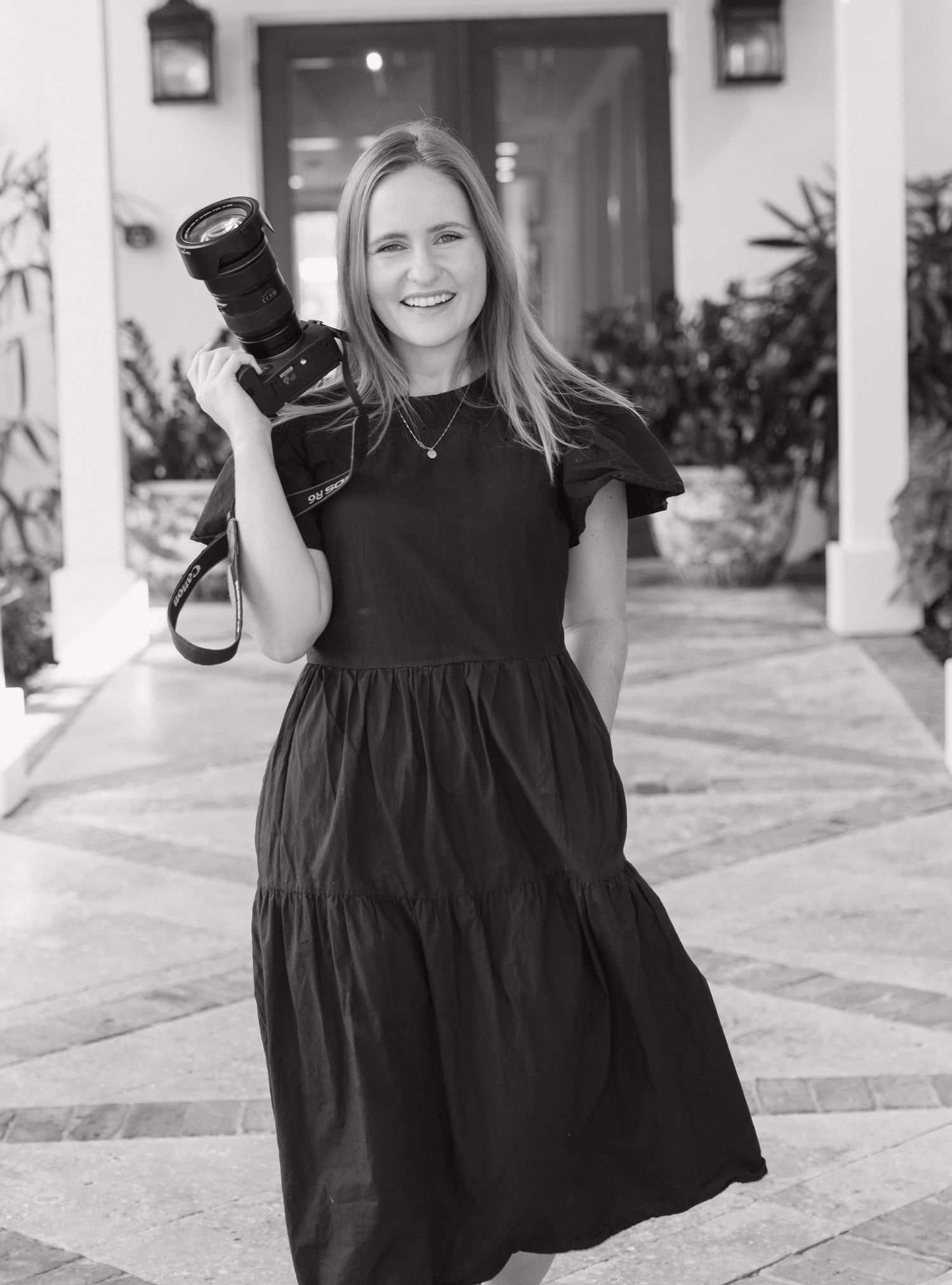 A series of black and white photos showing someone twirling in a black dress on a patio with white columns.