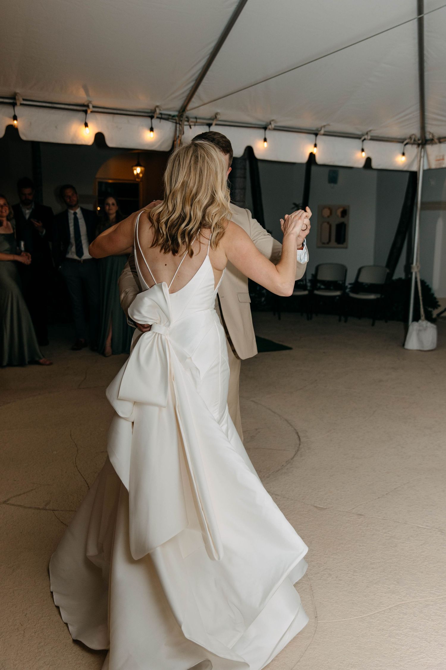 A sequence of five photos showing a person in a white dress twirling and dancing at what appears to be a wedding reception.