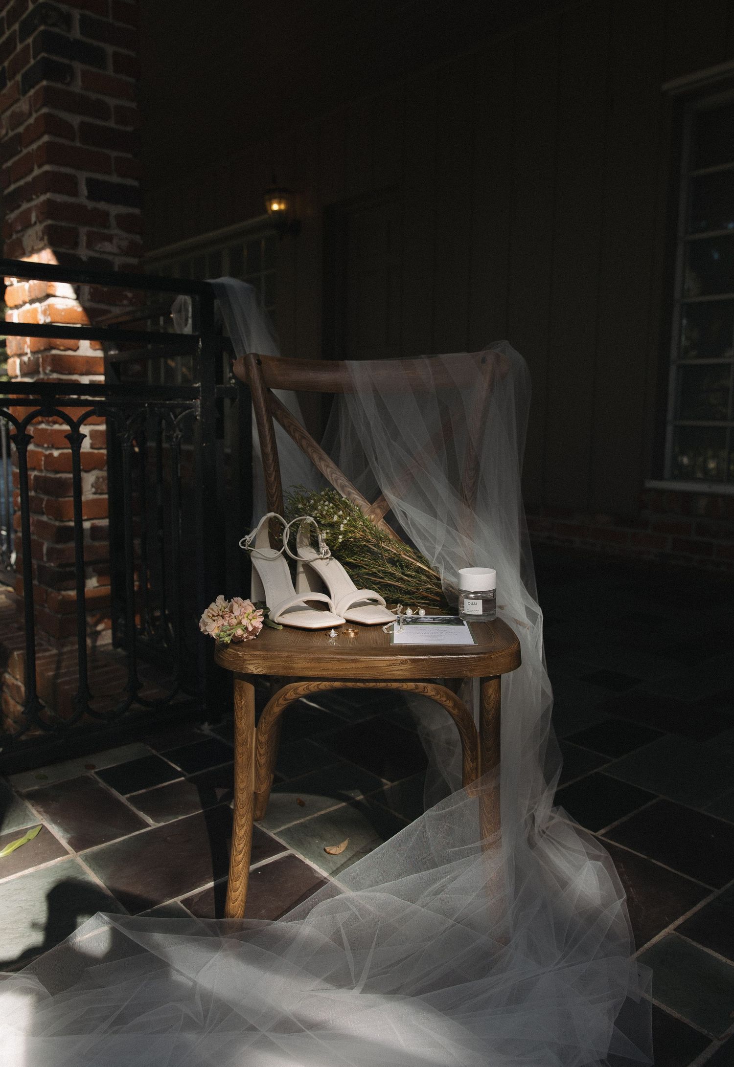 Eerie dark room interior with white gauzy fabric draped across wooden furniture creating a ghostly atmosphere.
