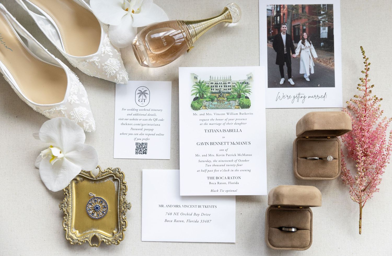 A romantic wedding details photo styling with invitations, vintage frames, flowers, and beige accessories laid out in a row.