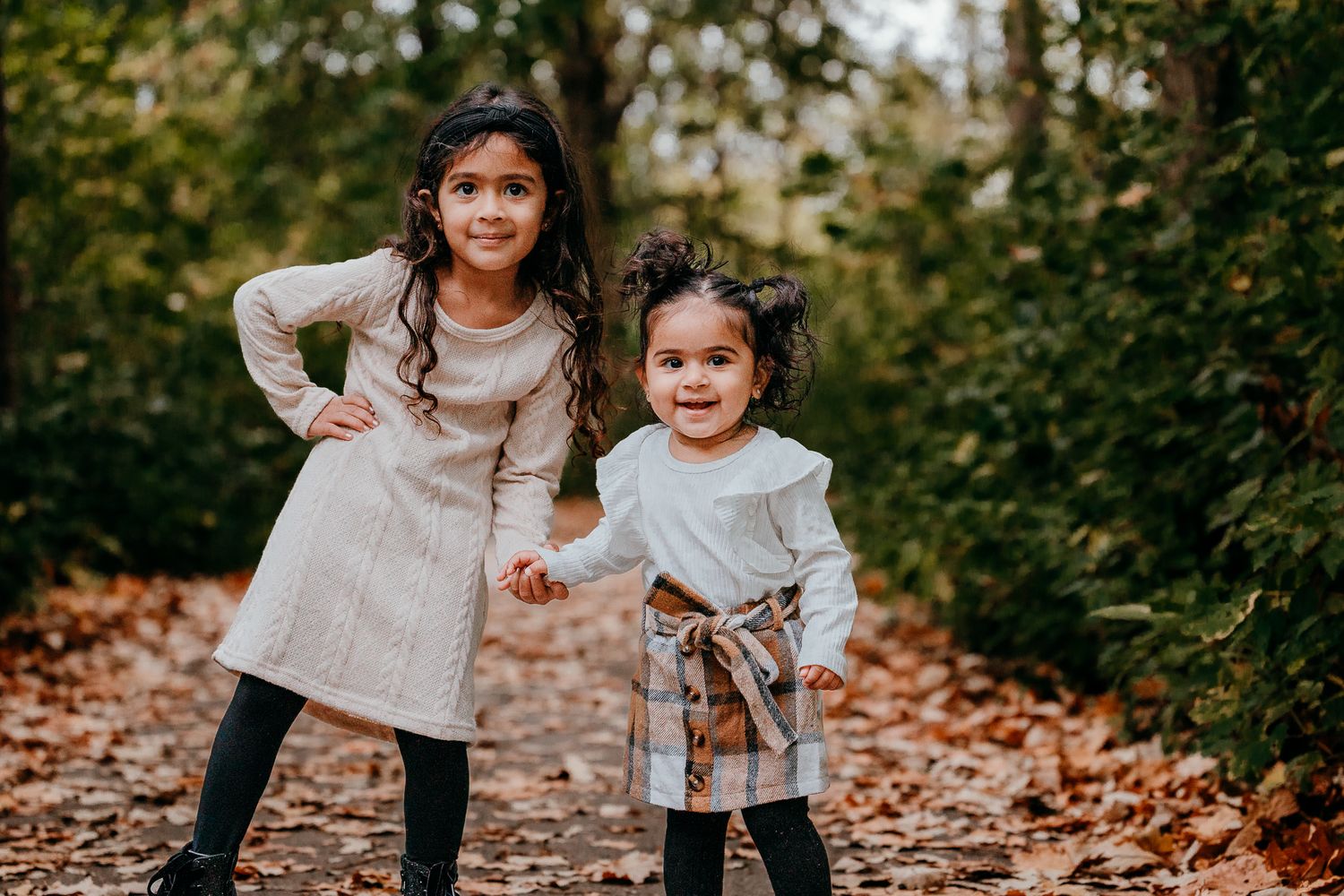 Children playing in fall leaves during family photography session