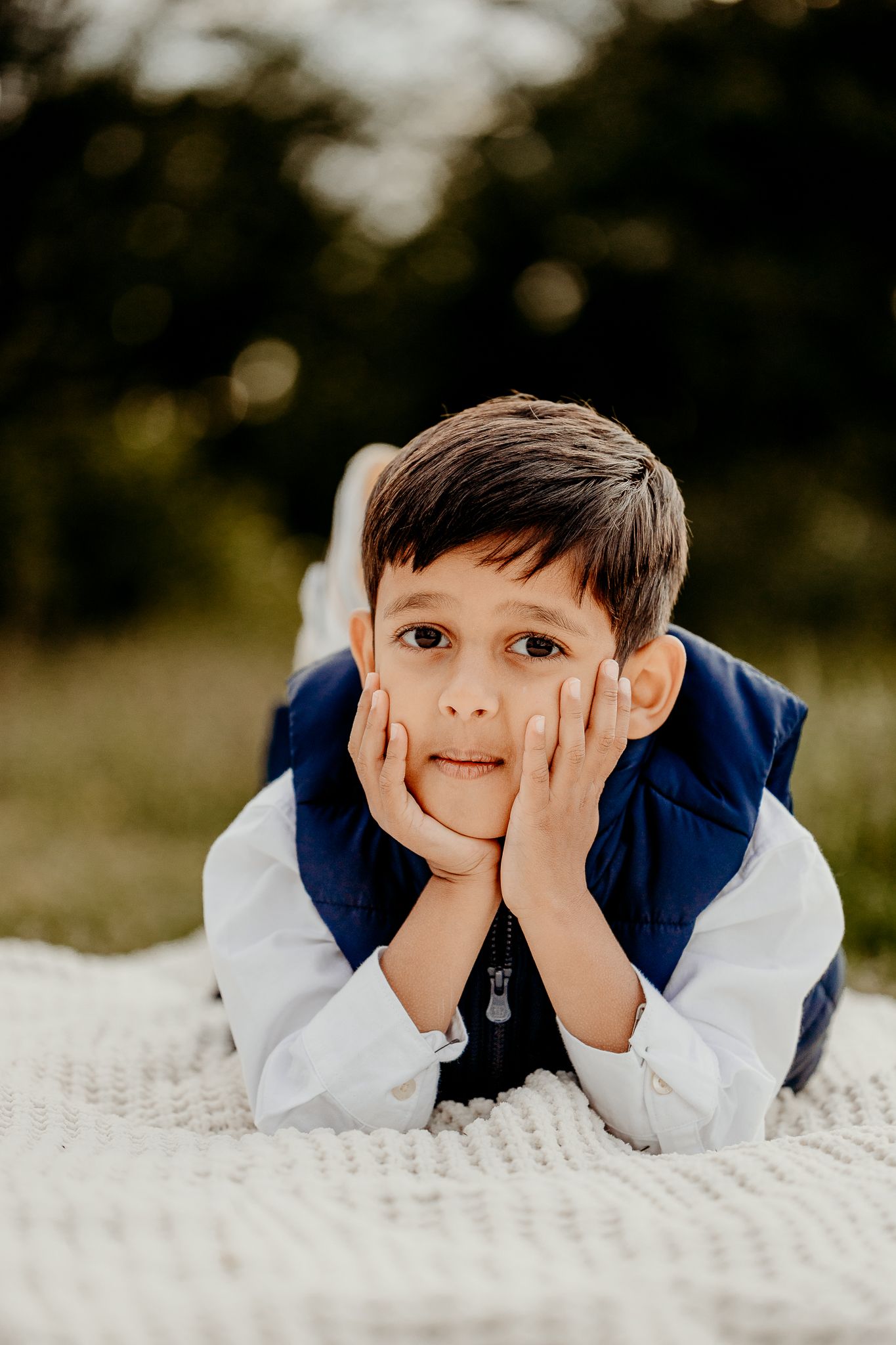 Son posing on blanket for a thoughtful fall family photo session in Schaumburg Forest Preserve
