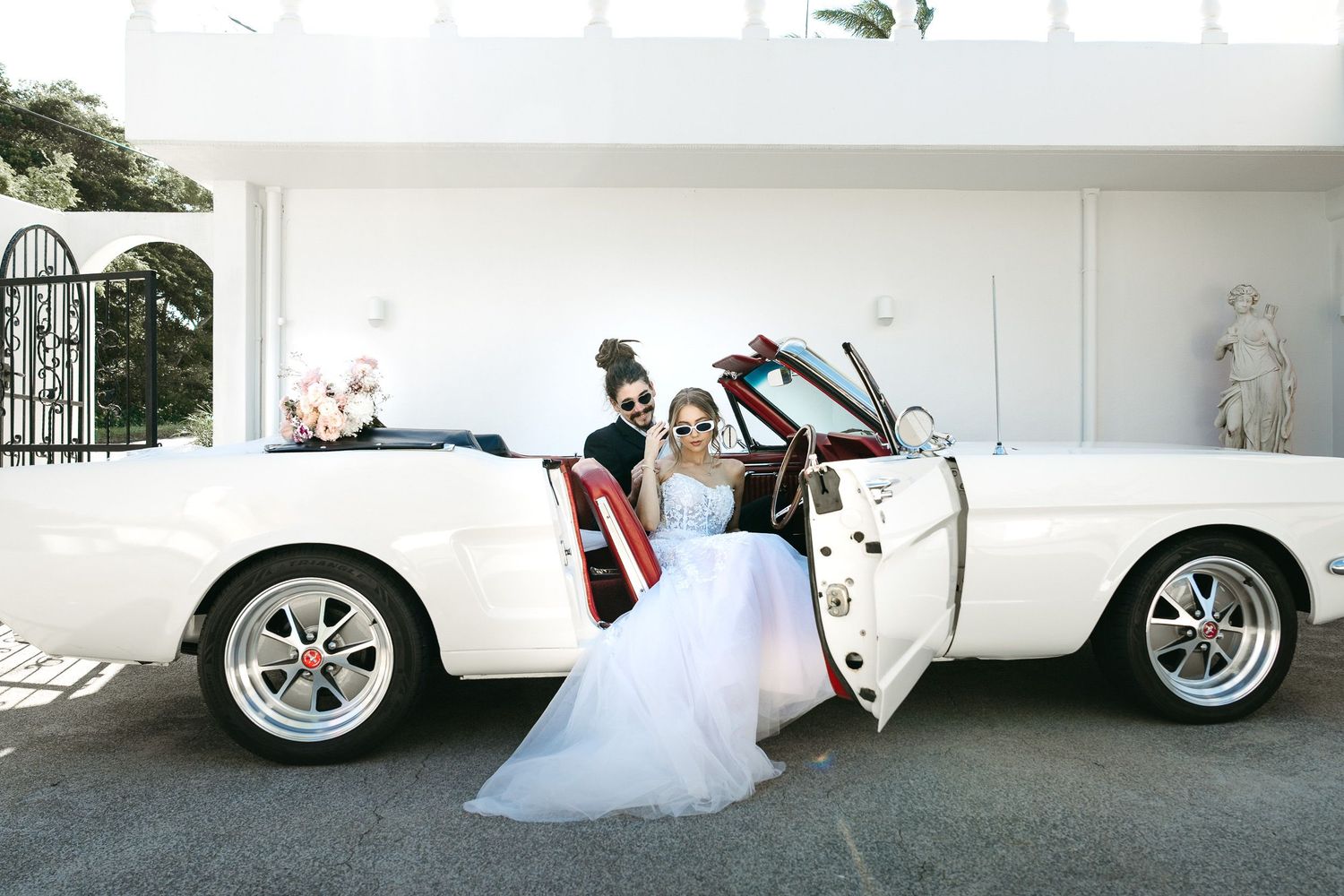 Bride standing beside classic wedding car at A Villa Gail