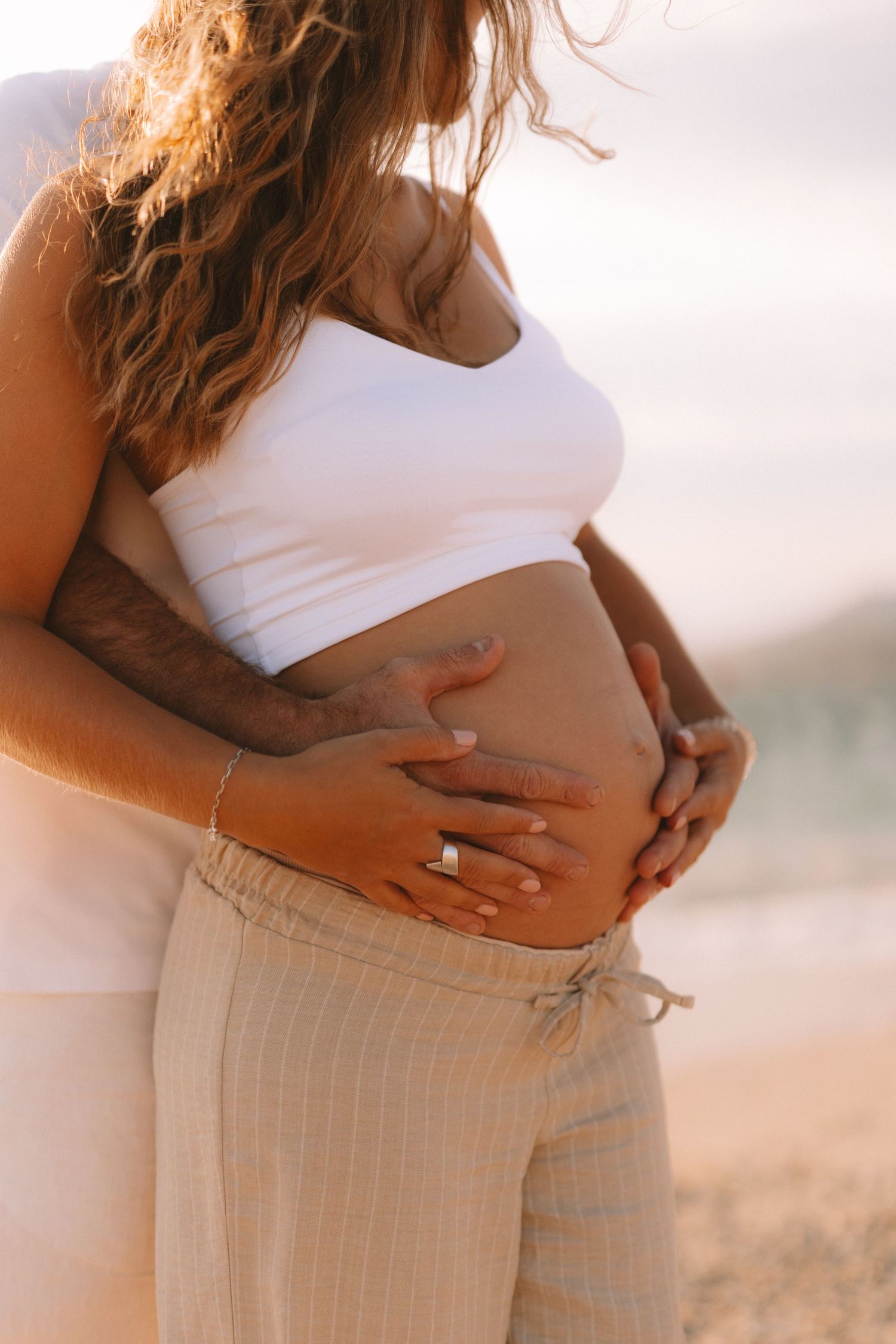 Side view progression of pregnancy photos showing growing belly against soft natural lighting.