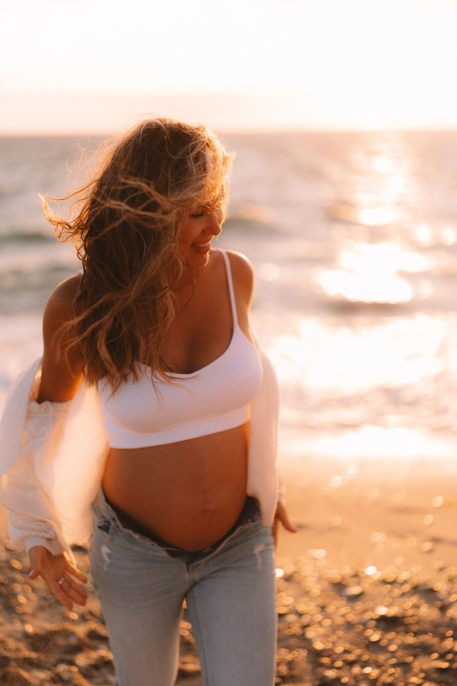 A series of maternity photos showing a woman in white top and light pants against a sunset beach backdrop.
