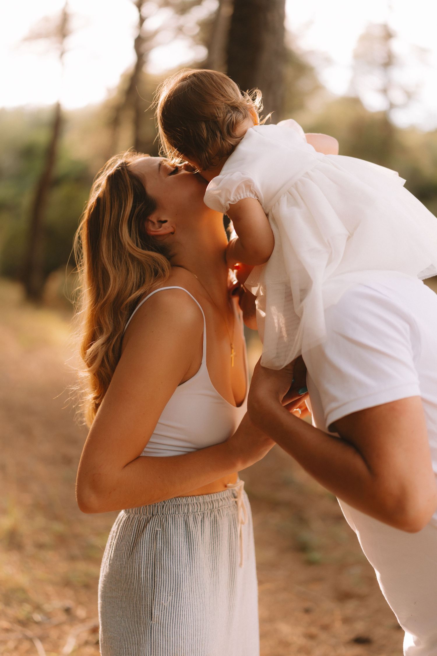 A romantic couple in white and gray outfits share intimate moments in a series of outdoor sunset photographs.
