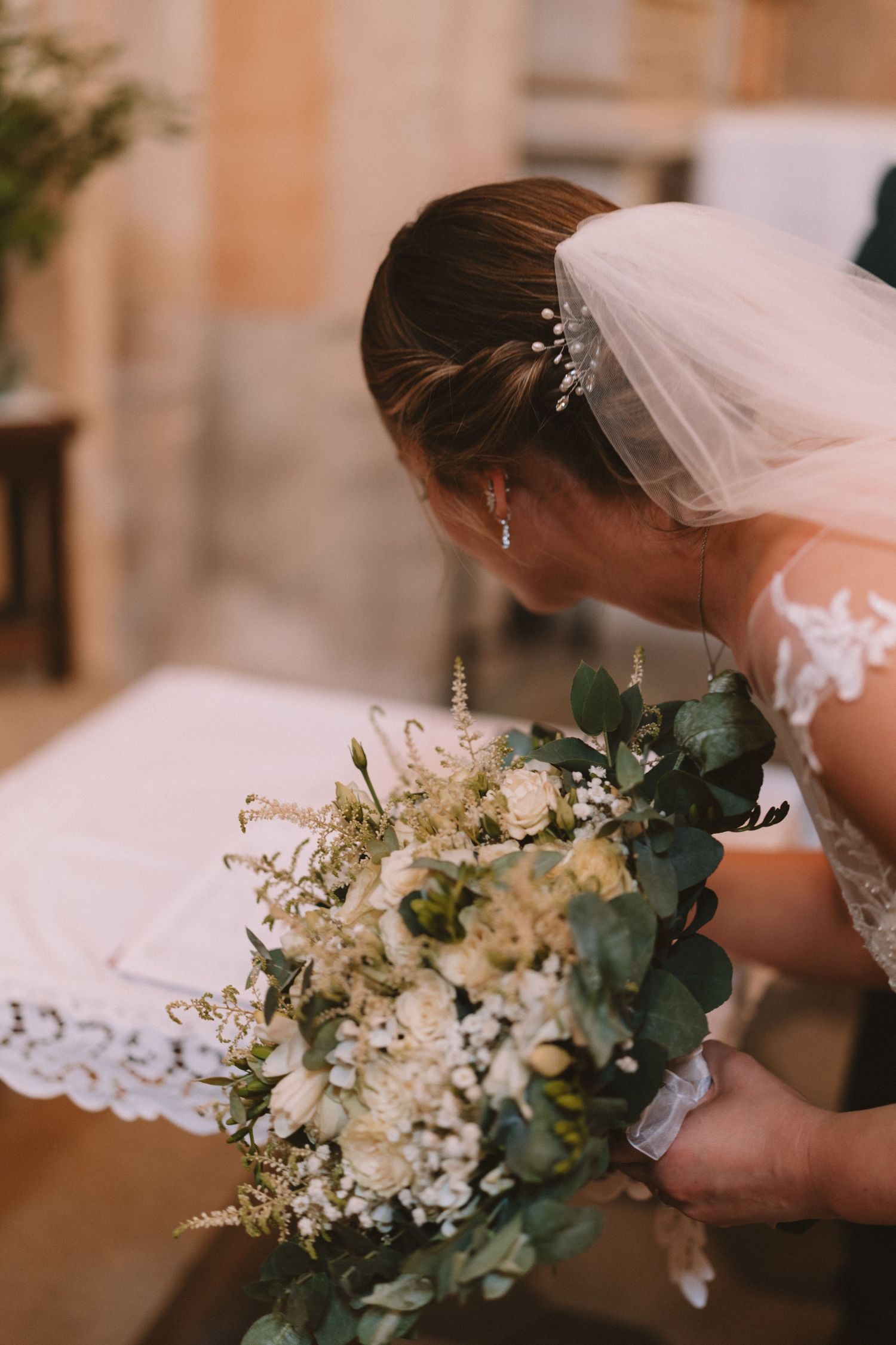 A close-up series of wedding photos showing a delicate white bridal bouquet with roses and eucalyptus leaves.