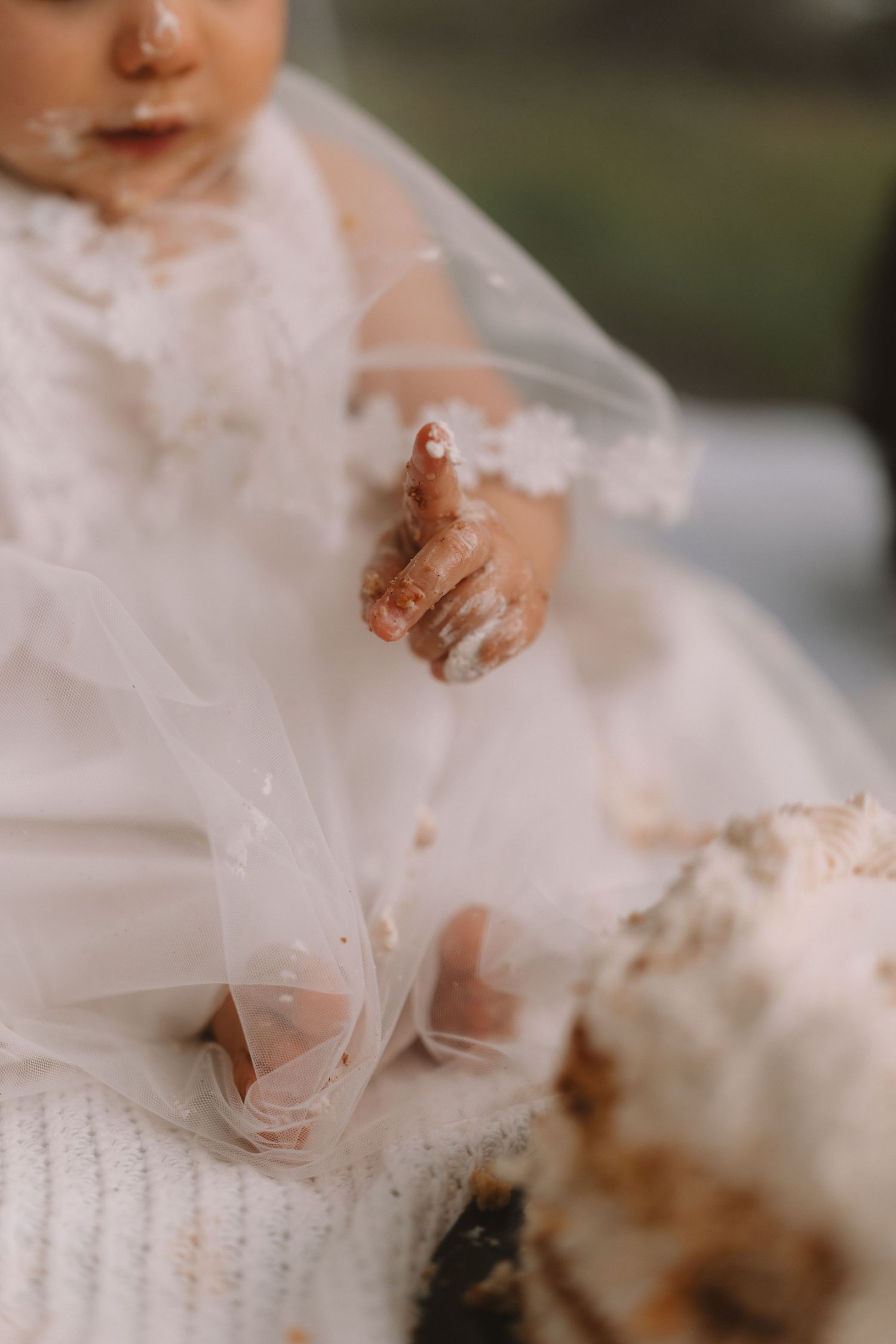 A baby's hands covered in chocolate smear and mess while playing with dessert.