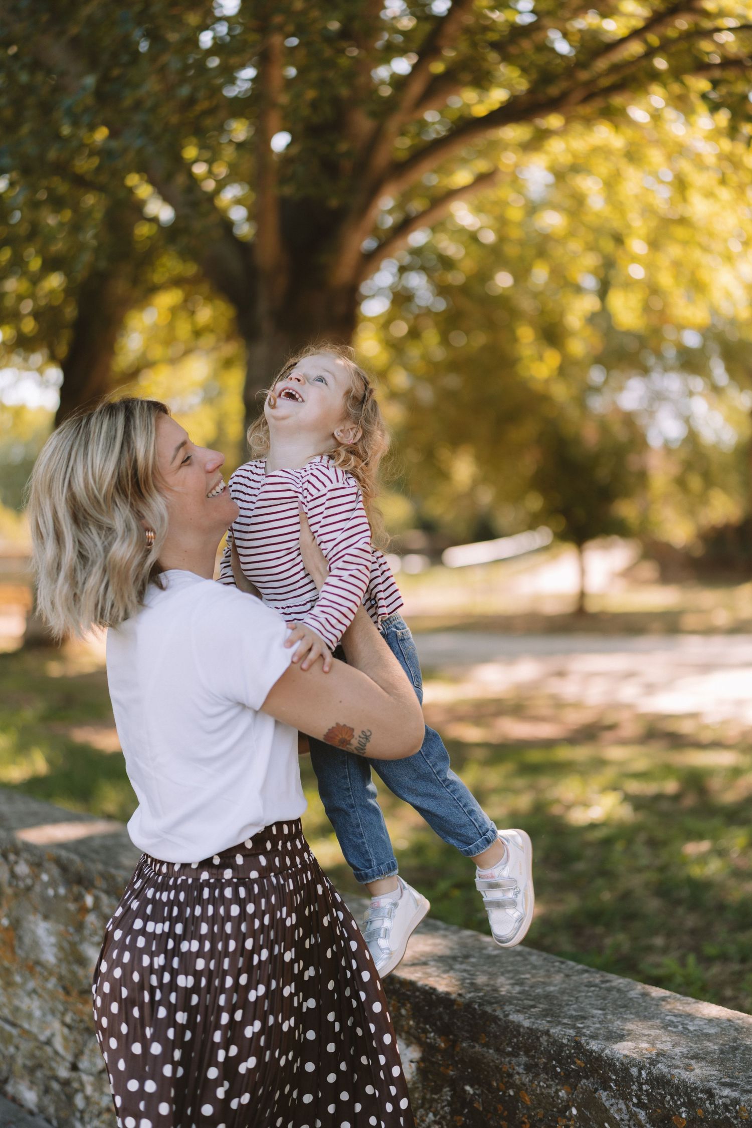 Joyful moments captured in sequence showing affectionate play on a rustic stone wall during golden hour.