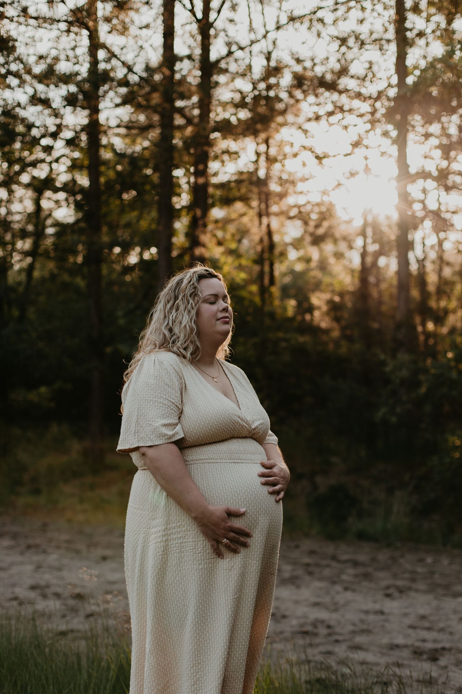 Een vrouw met een zwangere buik in het bos