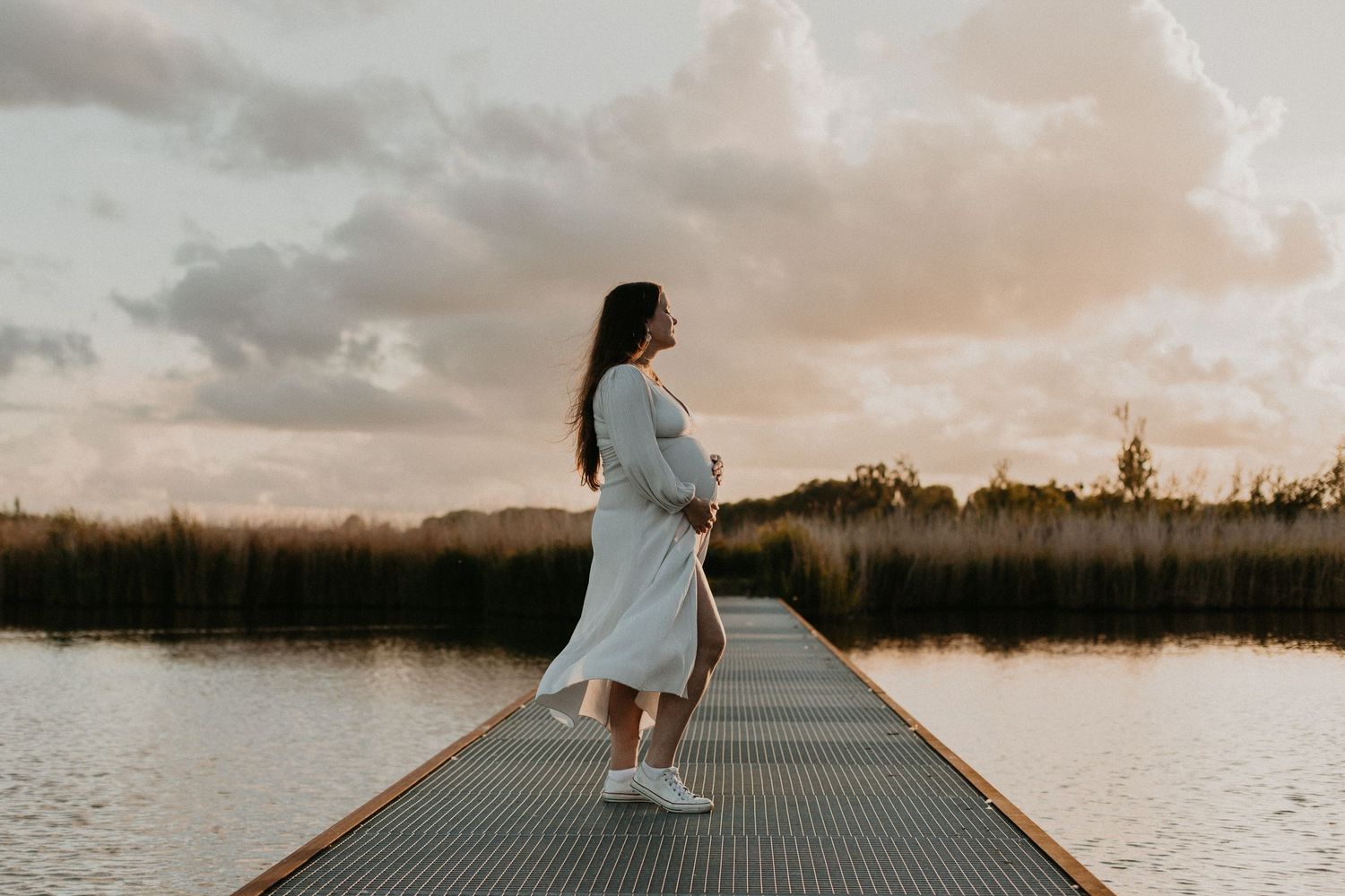 Magische zonsondergang met een prachtige zwangere vrouw.