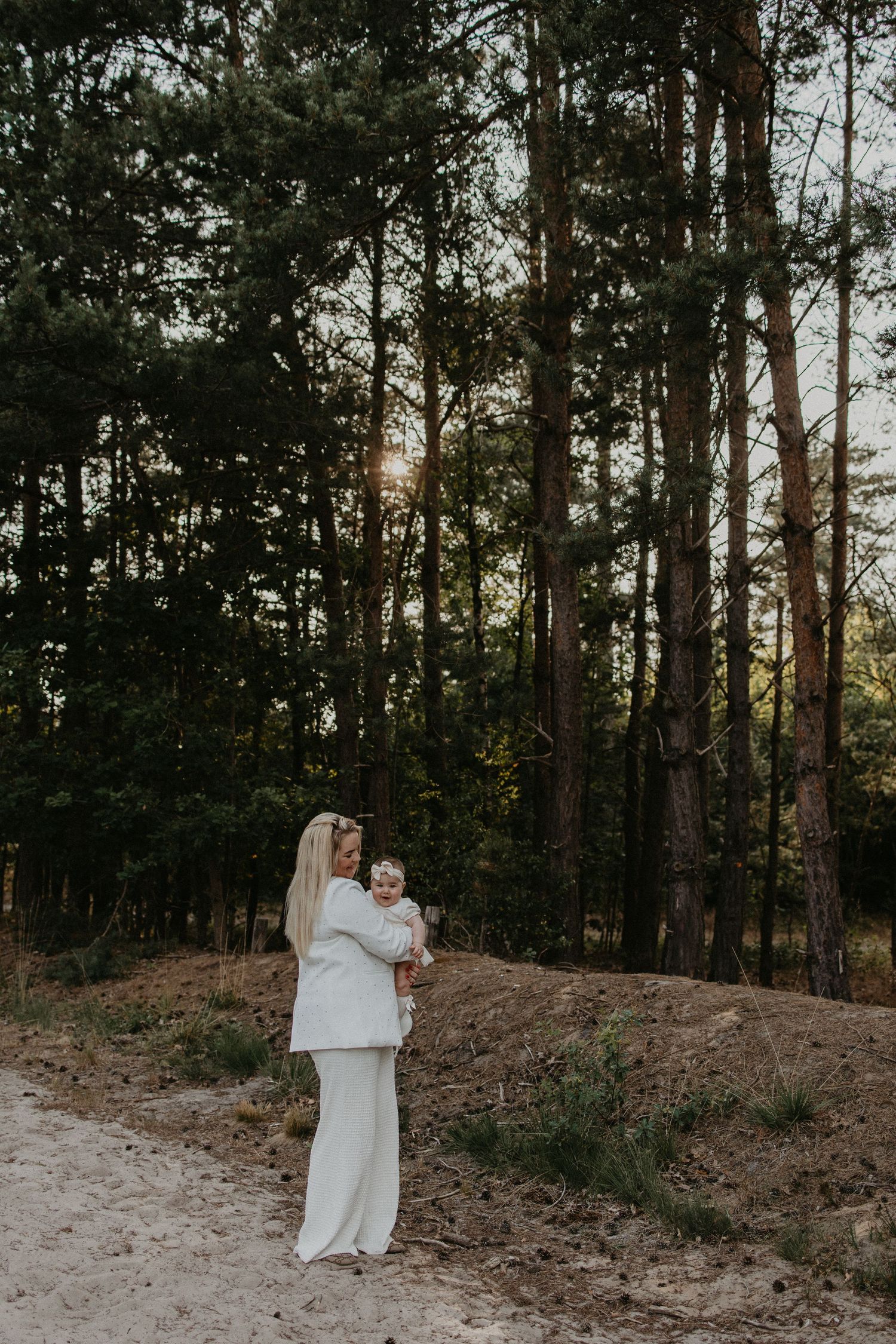 Intiem moment van een moeder met haar 7 maanden oude kindje in het bos, genietend van de natuurlijke, serene omgeving.