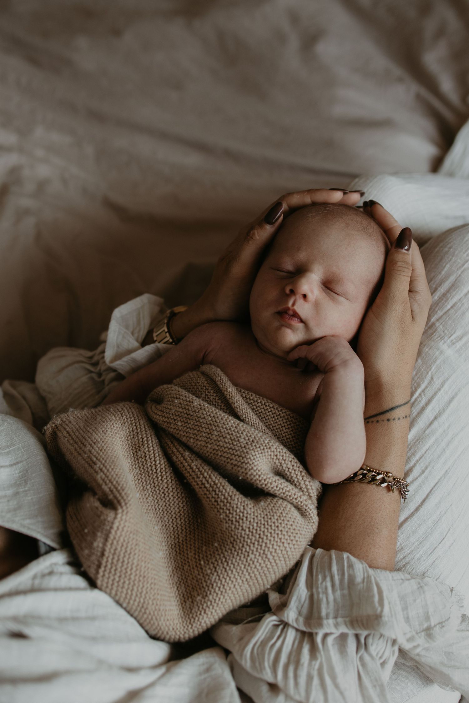 Kindje in een fijne cocoon bij zijn moeder op schoot