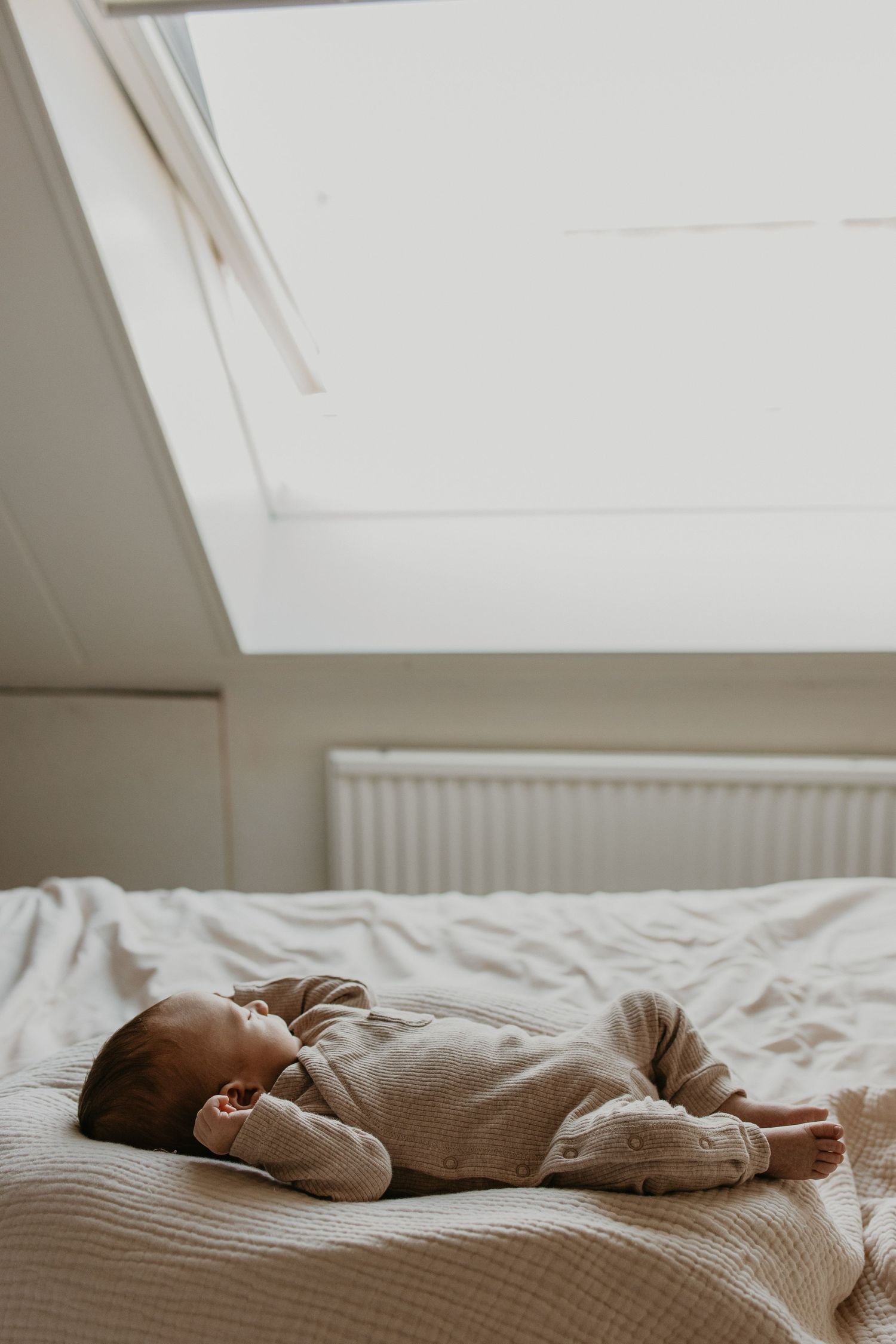 Lief klein jongentje dat op het grote bed ligt van zijn ouders.