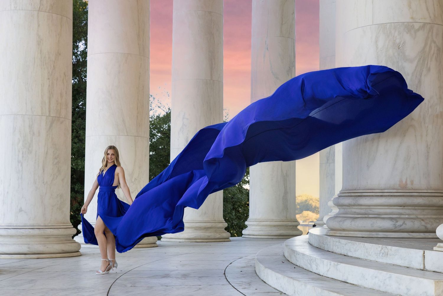 American flags wave against a backdrop of classical columns at the Jefferson Memorial during sunset. Flying Dress Photography