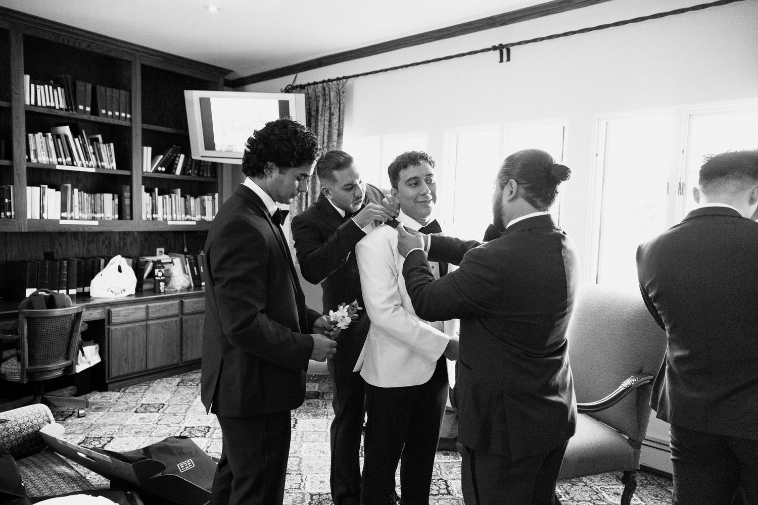 A black and white photo sequence showing people in suits moving through an office space and interacting at a desk.