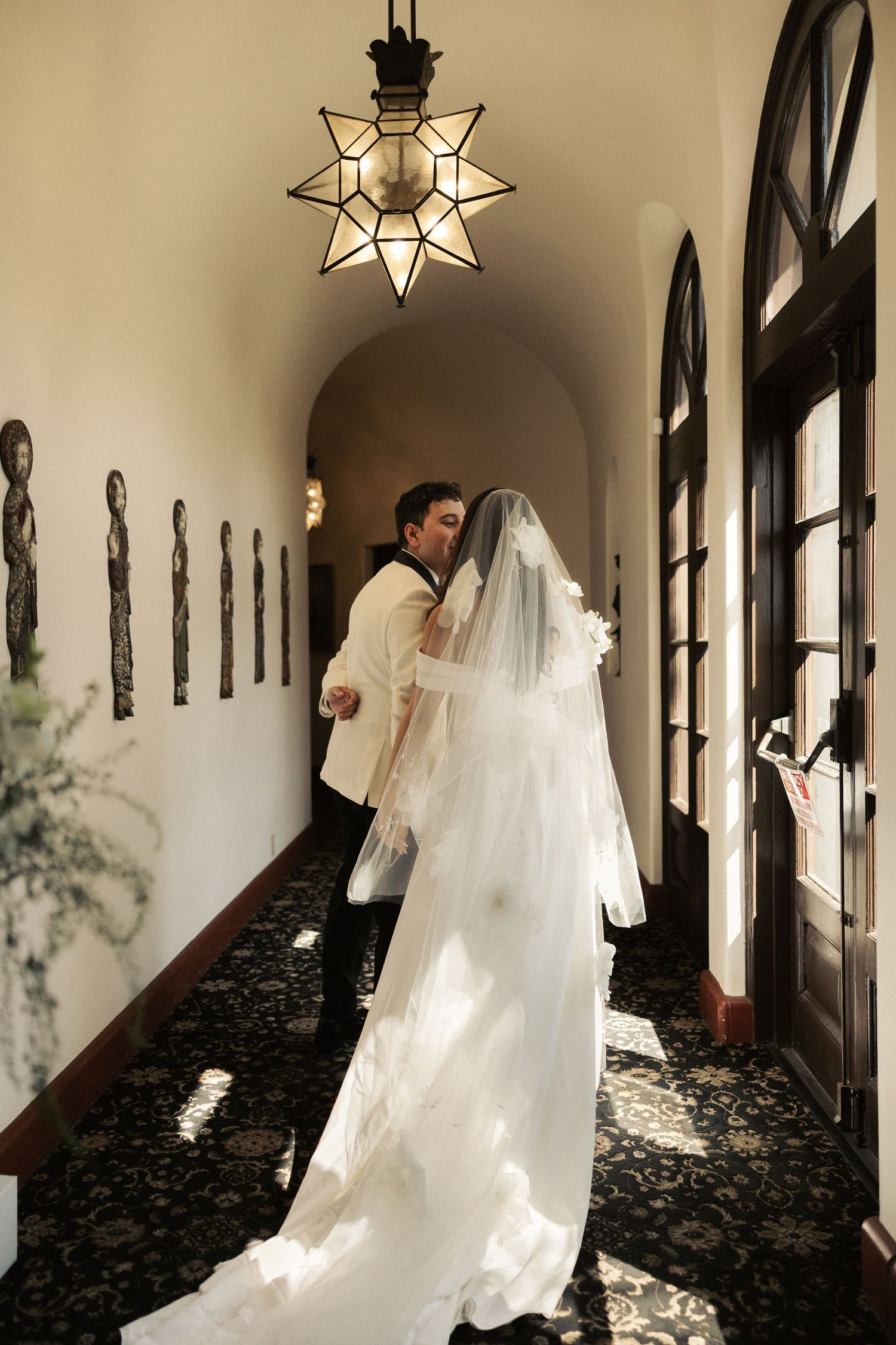 A series of photos showing a bride and groom dancing playfully in an elegant hallway with star-shaped pendant lights.