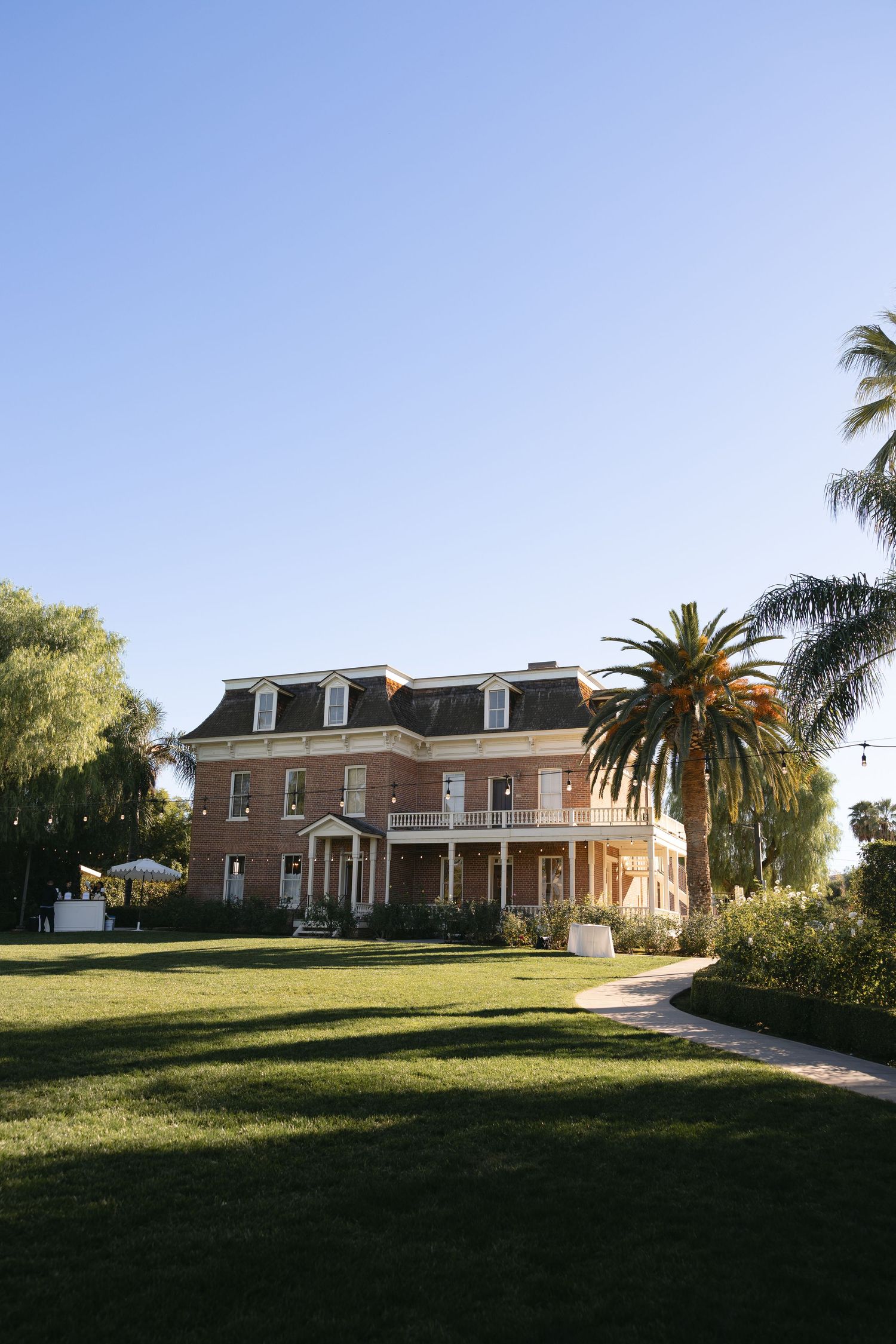 Historic mansion with palm trees and green lawn photographed from different angles in panoramic sequence.