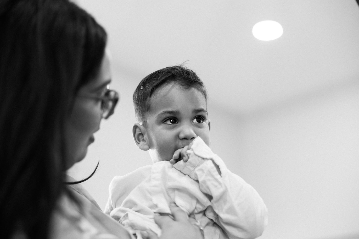 Black and white photo series showing different angles of a baby drinking from a bottle in someone's arms.