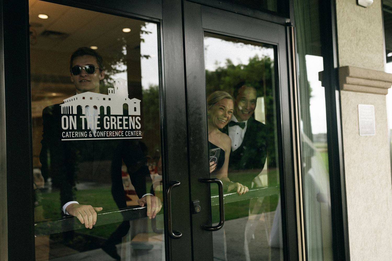 Customer sits by window inside City Greens eatery with signage visible on glass door.