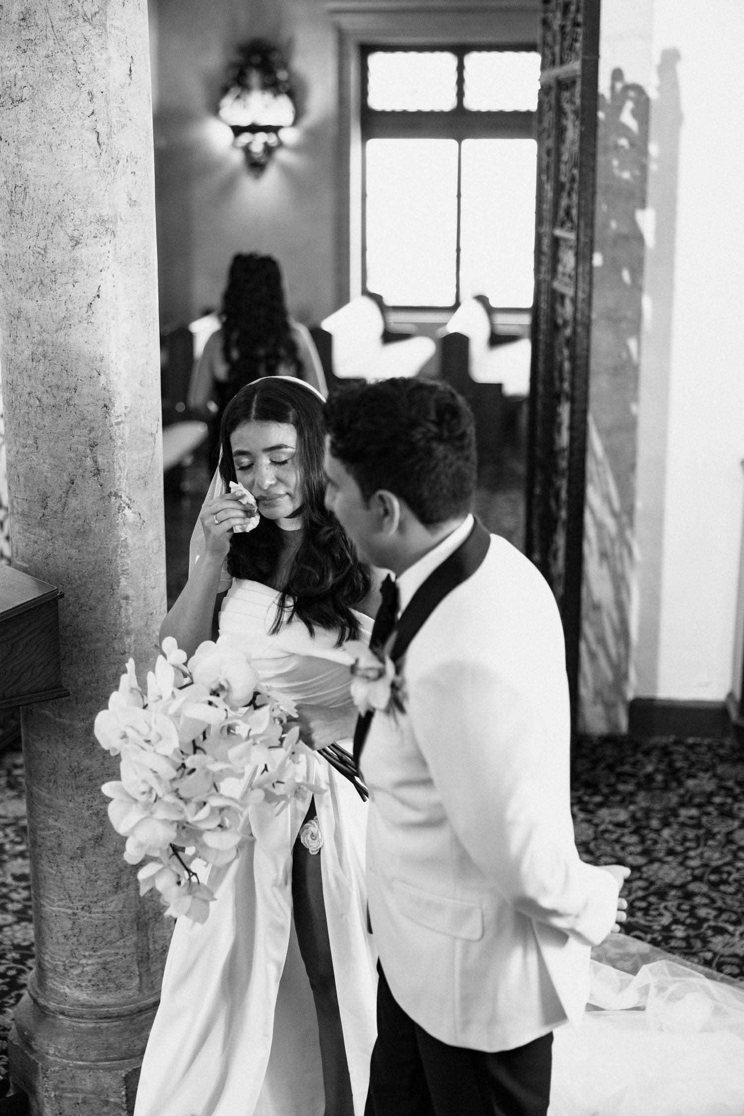 Black and white wedding photos show joyful moments between couple with white lily bouquet in elegant venue.
