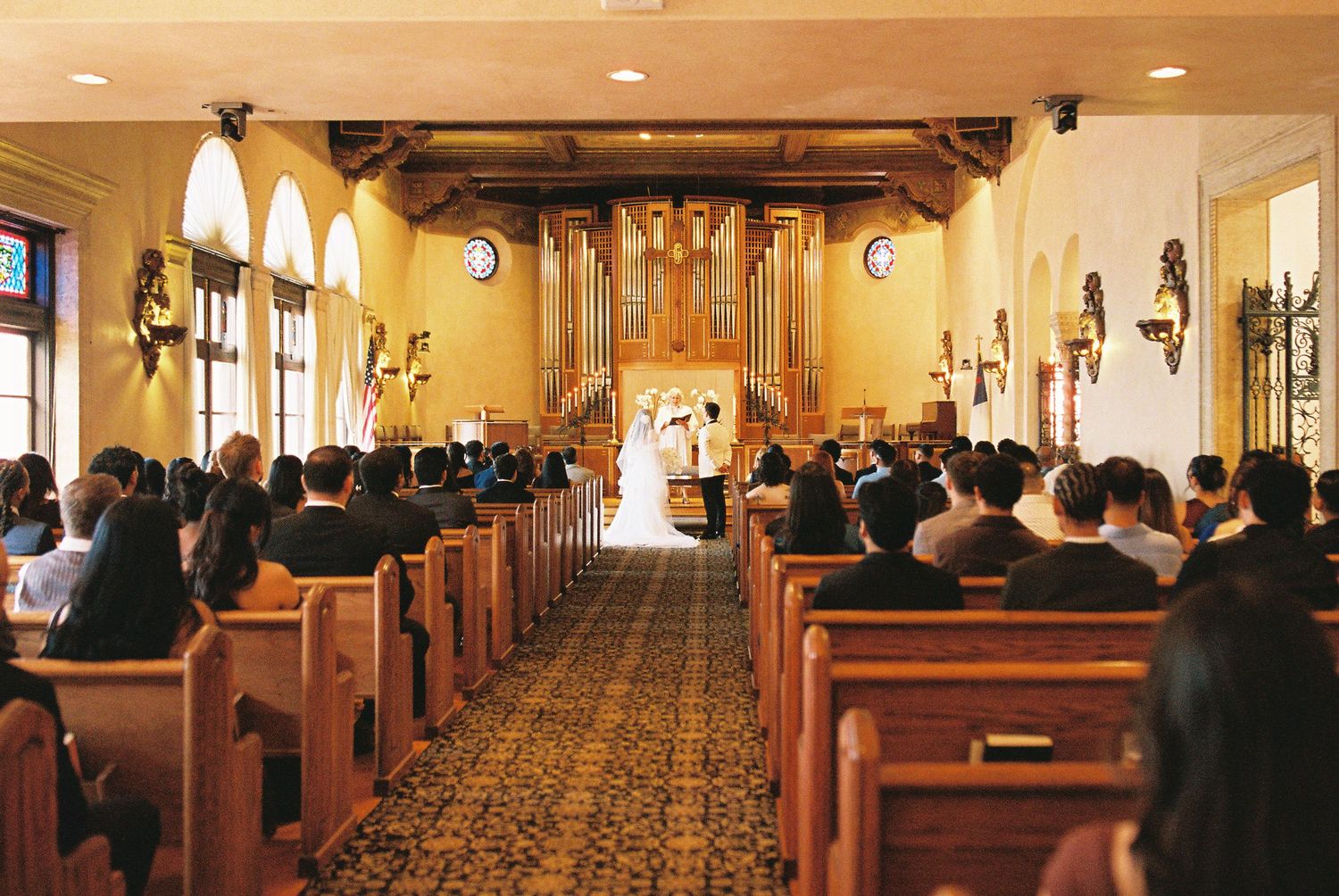 Interior view of a church sanctuary with wooden pews and warm lighting during a service.