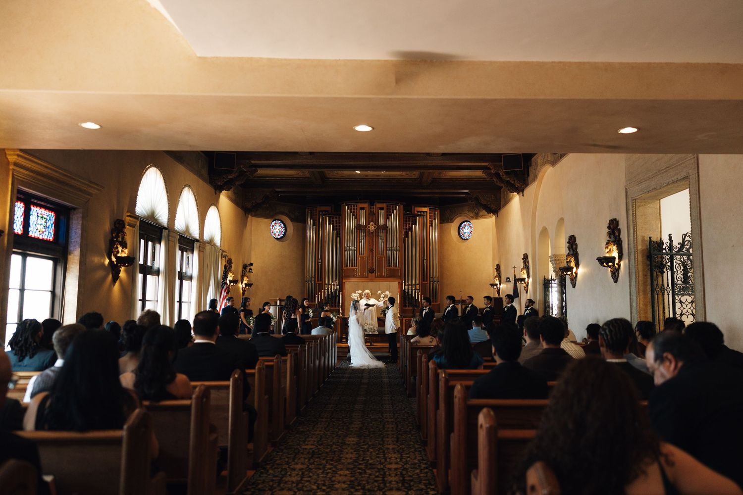 A panoramic view of a dimly lit church sanctuary with wooden pews and traditional architectural details.