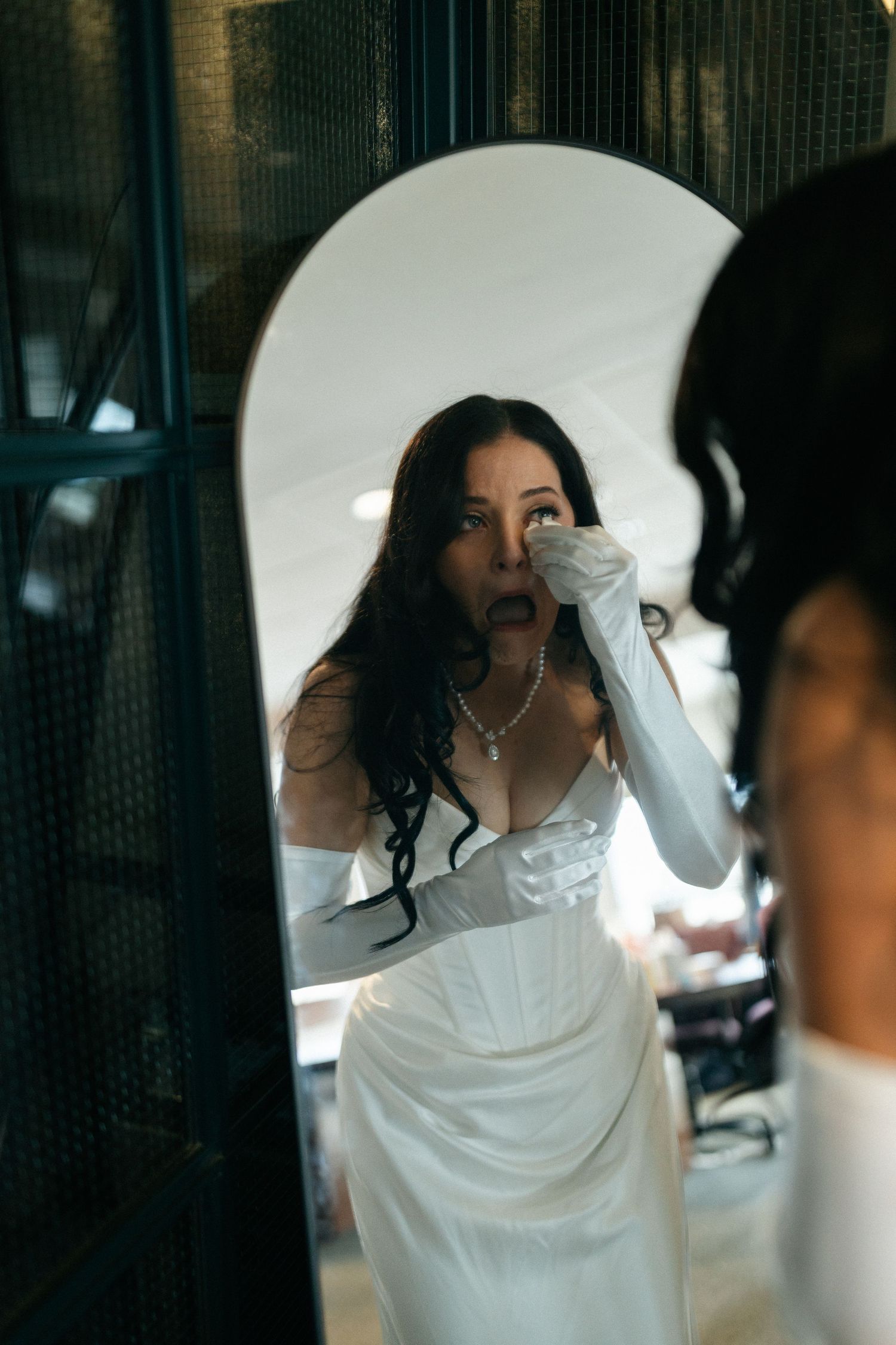 A sequence of photos showing a person in a white dress adjusting their veil during a wedding preparation.Micro wedding, elopement, intention