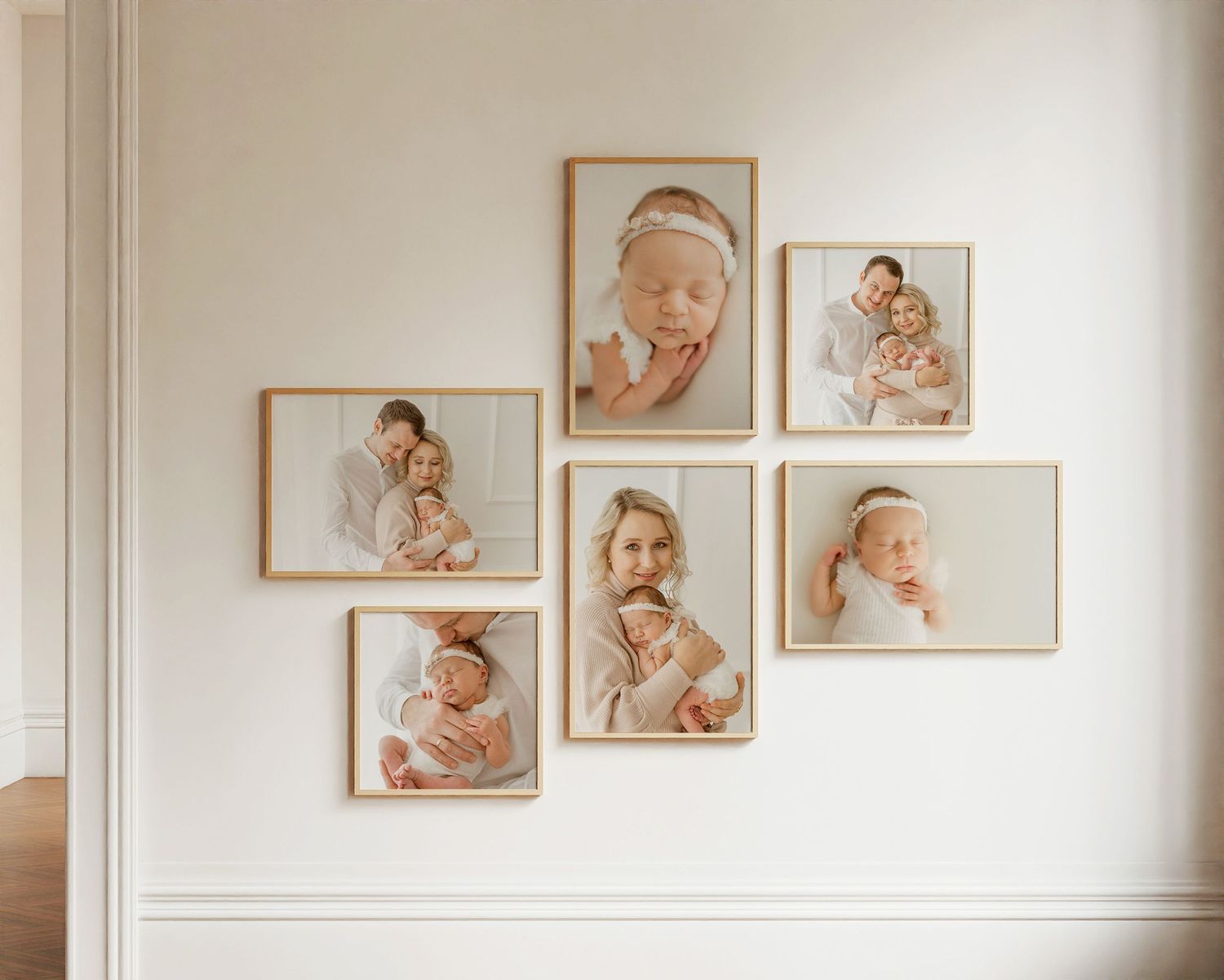 A collection of six natural-toned baby photographs arranged artistically in wooden frames on a white wall.