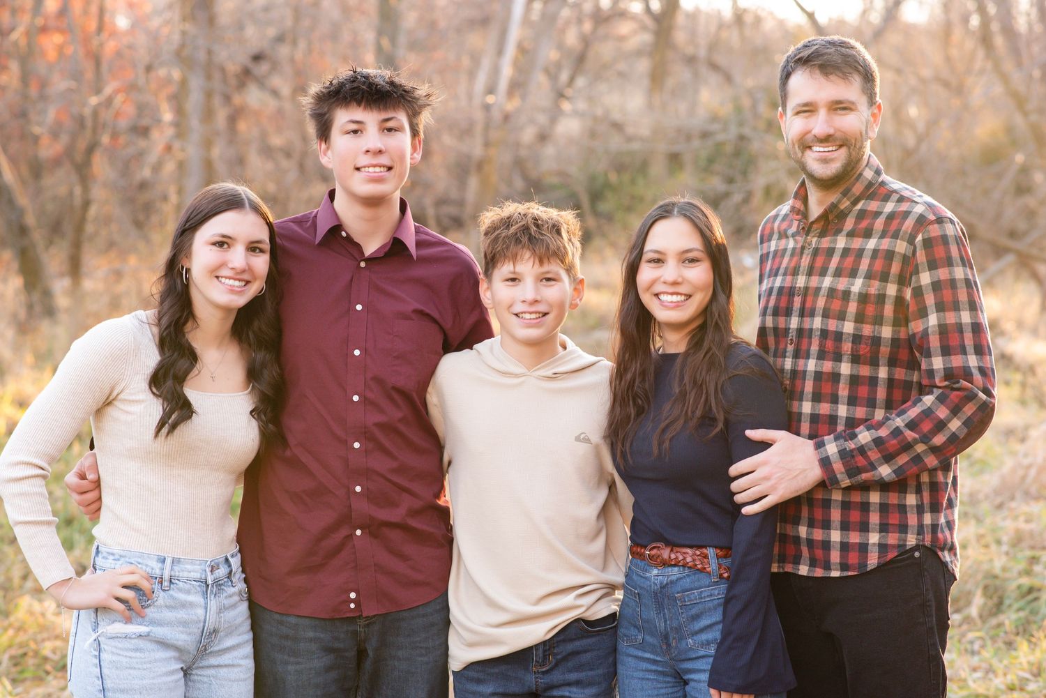 Family of five smiling and standing together during outdoor session in Gretna, Nebraska.