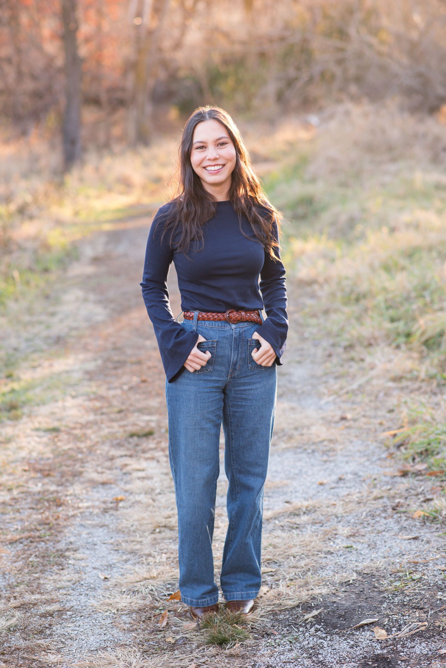 Young woman standing and smiling during an outdoor photoshoot in Omaha, NE.