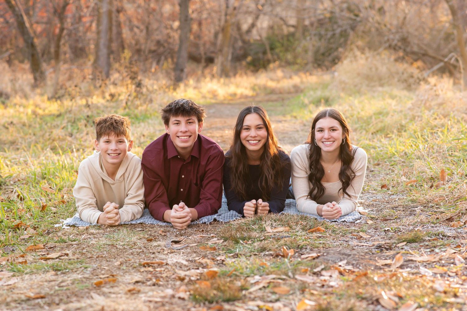 Family of five smiling and sitting together during outdoor session in Gretna, Nebraska.
