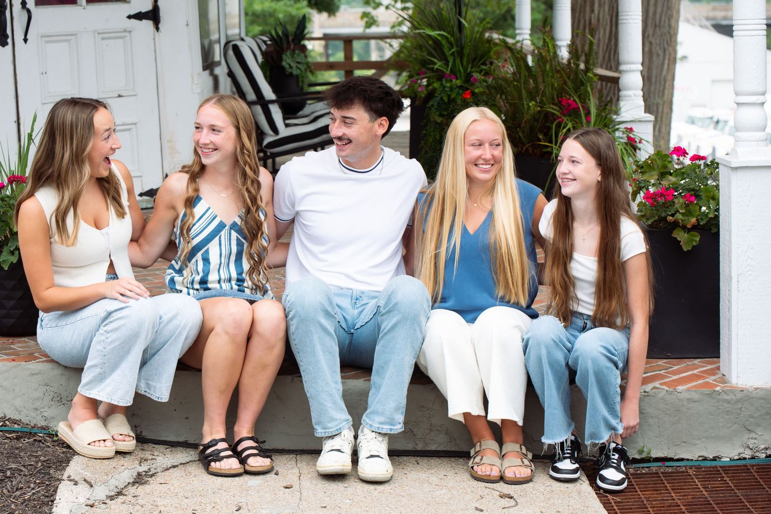 Family of five smiling and sitting together during outdoor session in Gretna, Nebraska.