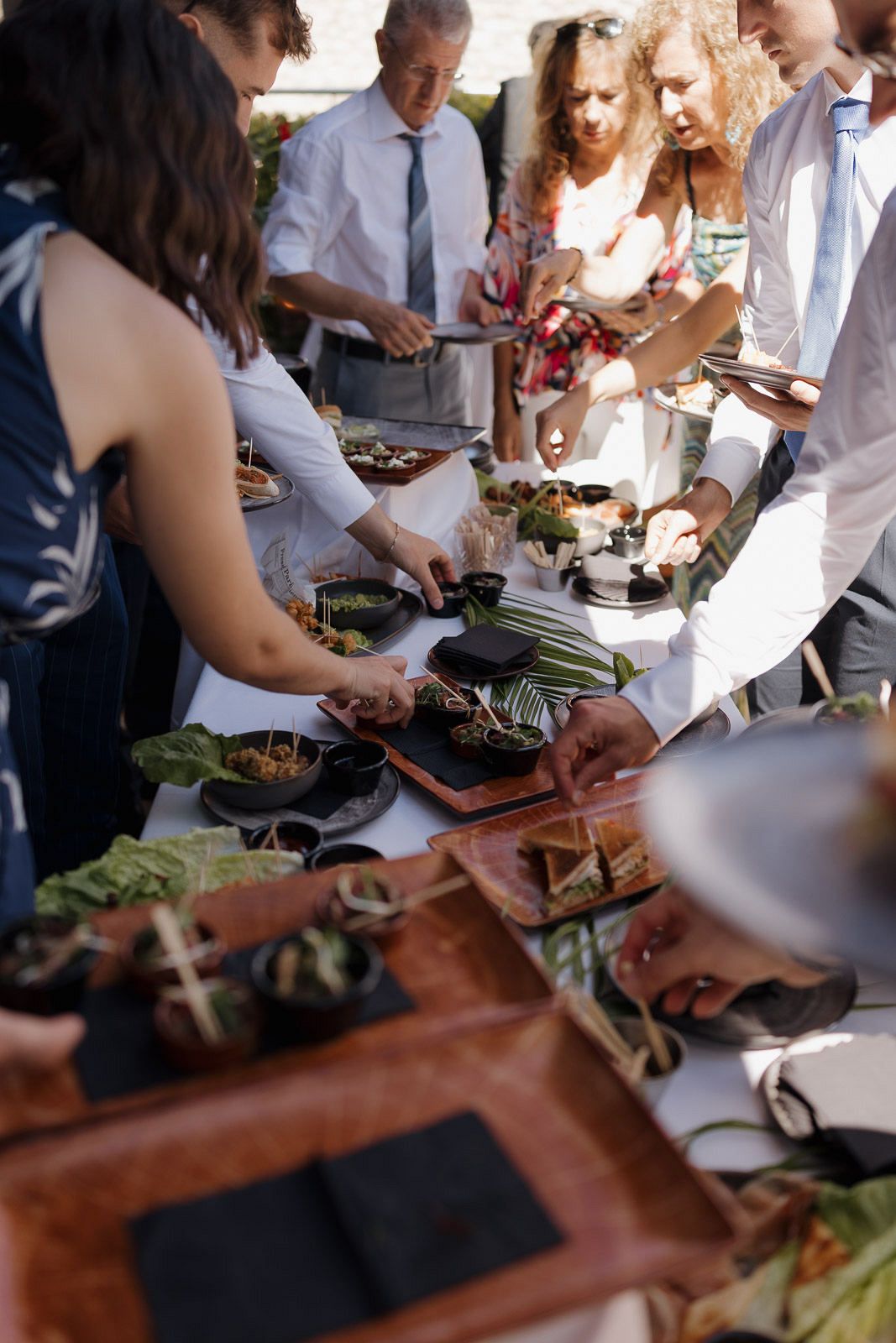 People gather around a table preparing food together at a casual cooking event or class.