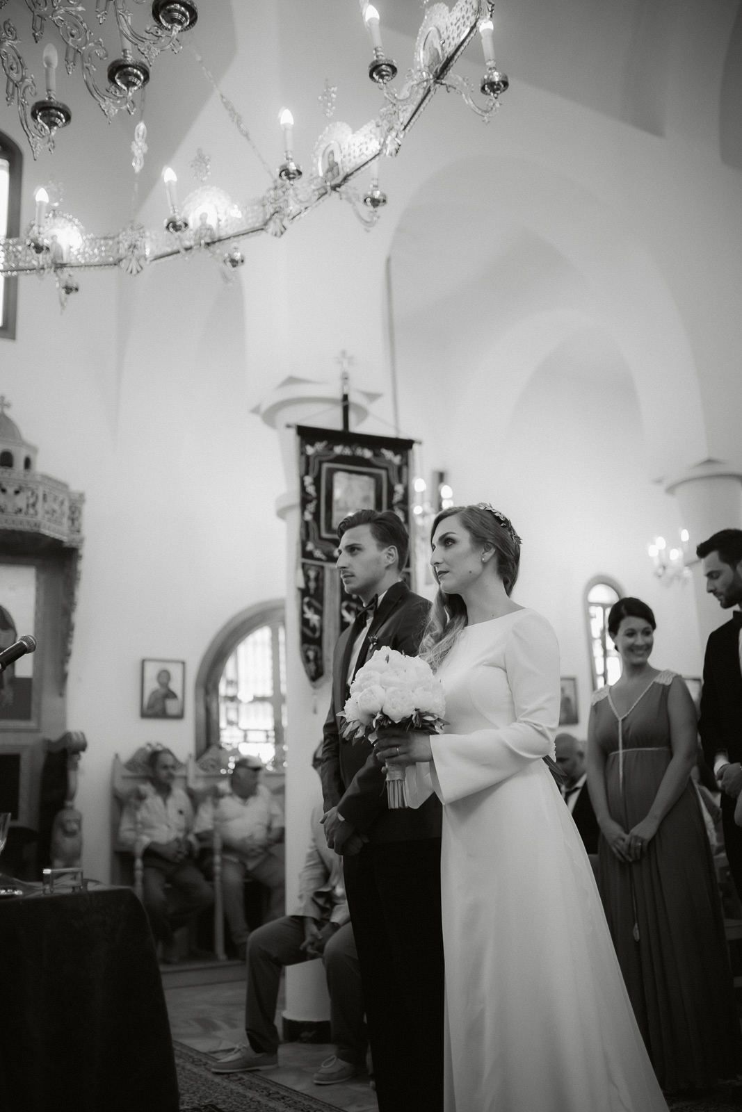 Black and white photo sequence showing intimate moments from a traditional church wedding ceremony with guests looking on.