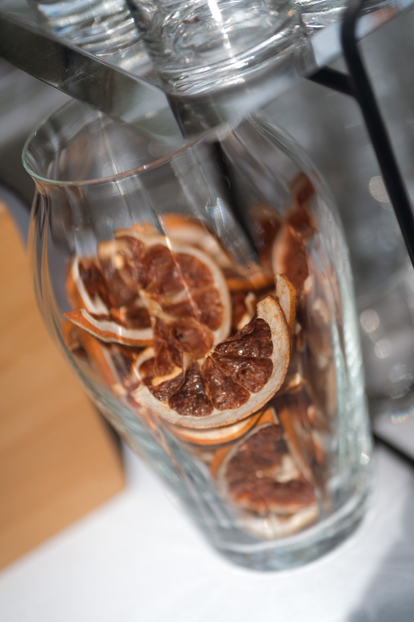 Dried citrus slices arranged in a clear glass vase, showcasing dehydrated orange and grapefruit pieces as decorative elements.