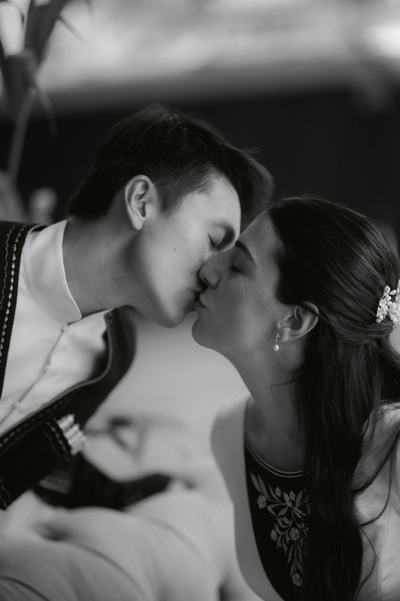 Black and white wedding photo of bride and groom sharing a romantic kiss.