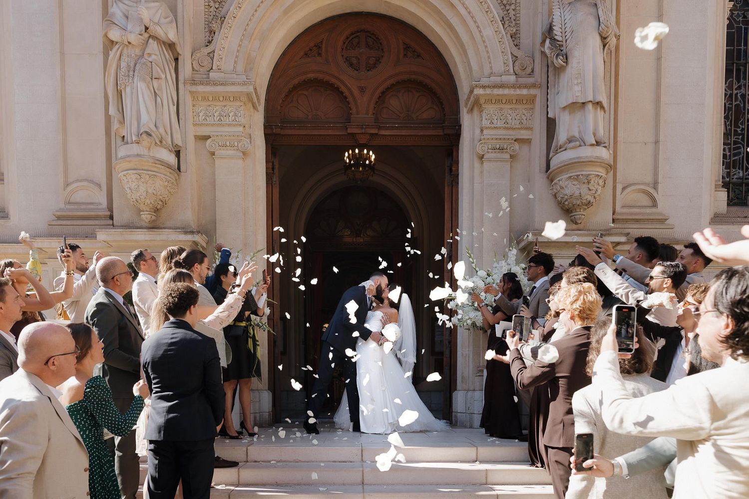Elegant couples dance together in a grand ballroom with ornate architecture and sparkling chandeliers.