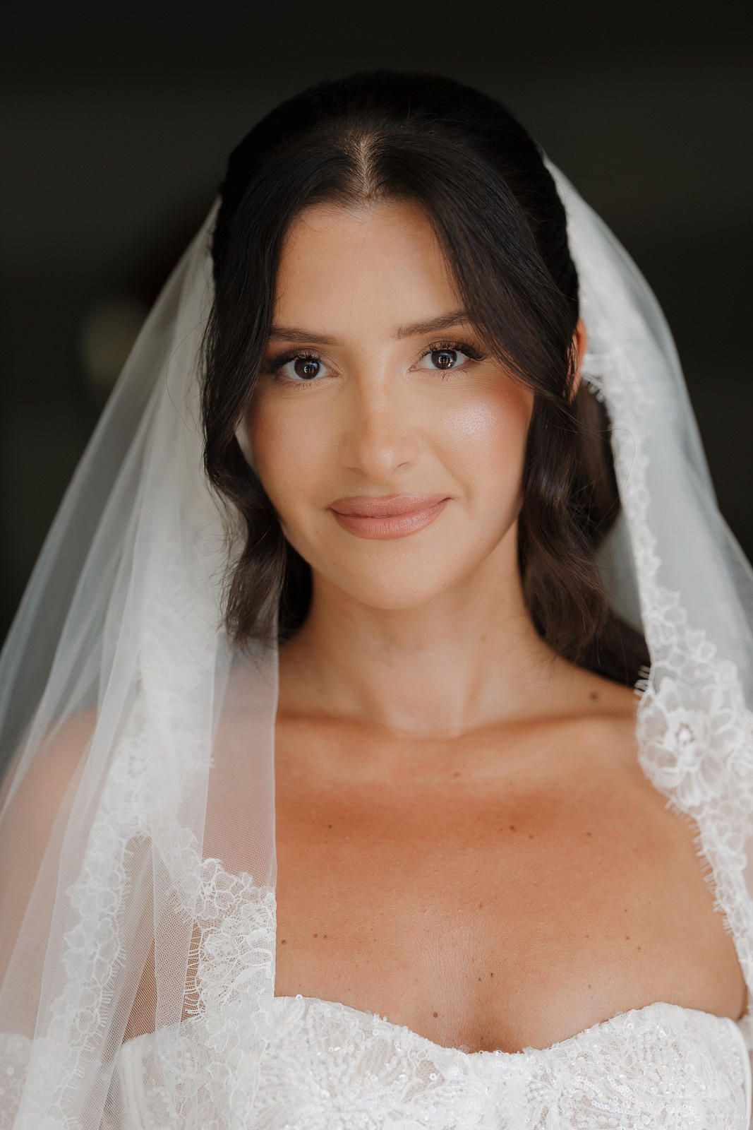 A bride wearing a white veil and wedding dress poses for a series of close-up portraits with a soft, natural smile.