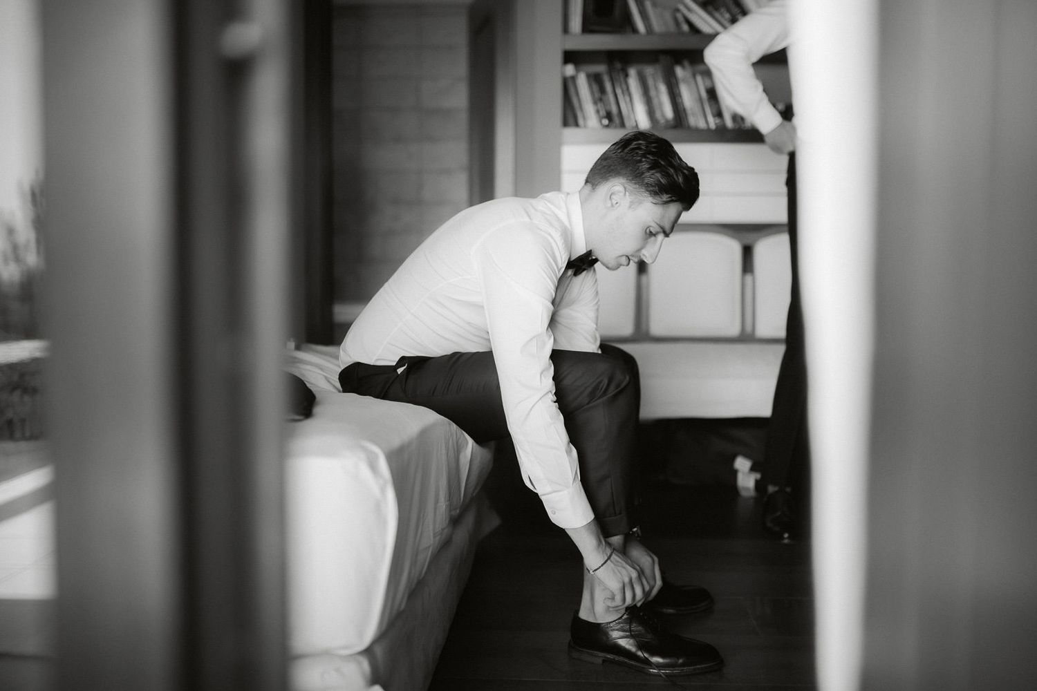 Black and white photo sequence showing someone jumping and flipping over a couch in an indoor setting.