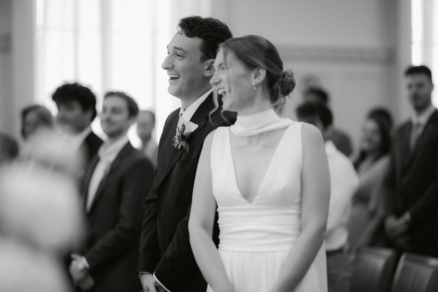 A black and white wedding photo capturing an intimate moment between newlyweds during their ceremony.