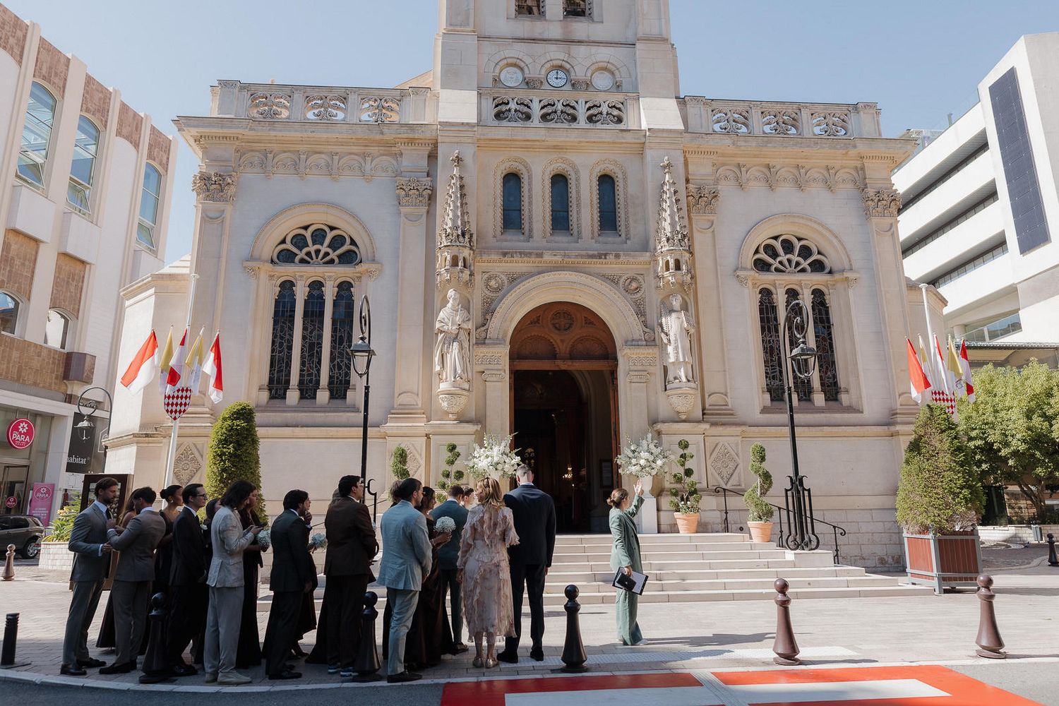 A panoramic view of a white church exterior with ornate architectural details and arched doorways.