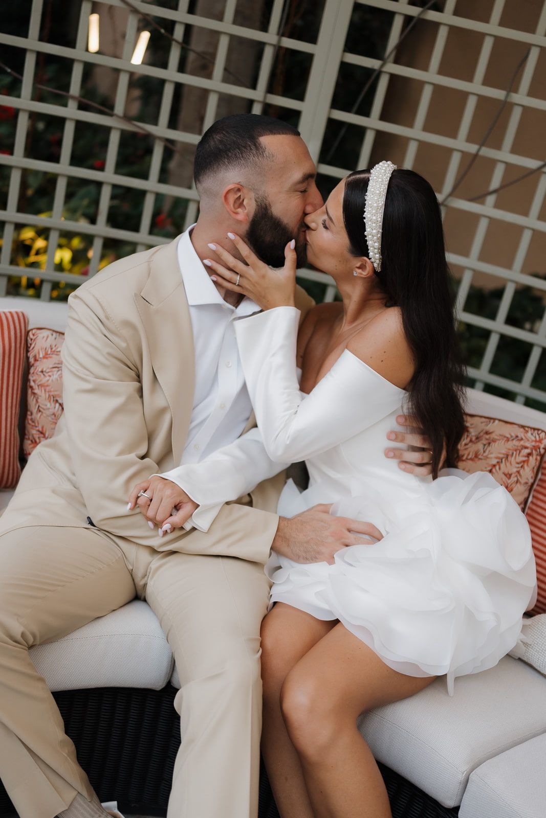 A romantic photoshoot sequence showing a couple in white and beige outfits embracing on an outdoor patio.
