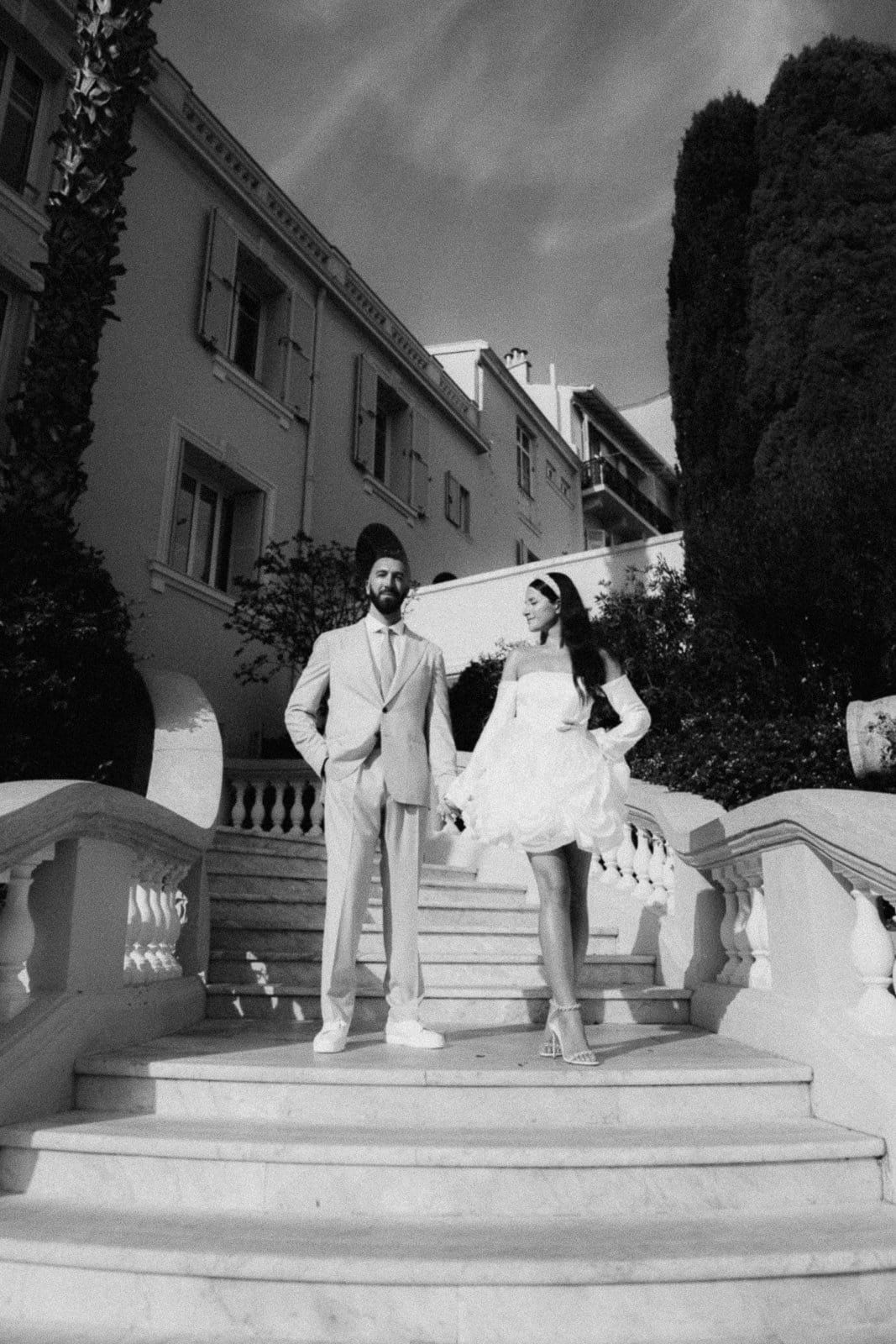Black and white photos of wedding party members posing dramatically on elegant outdoor stone staircase.
